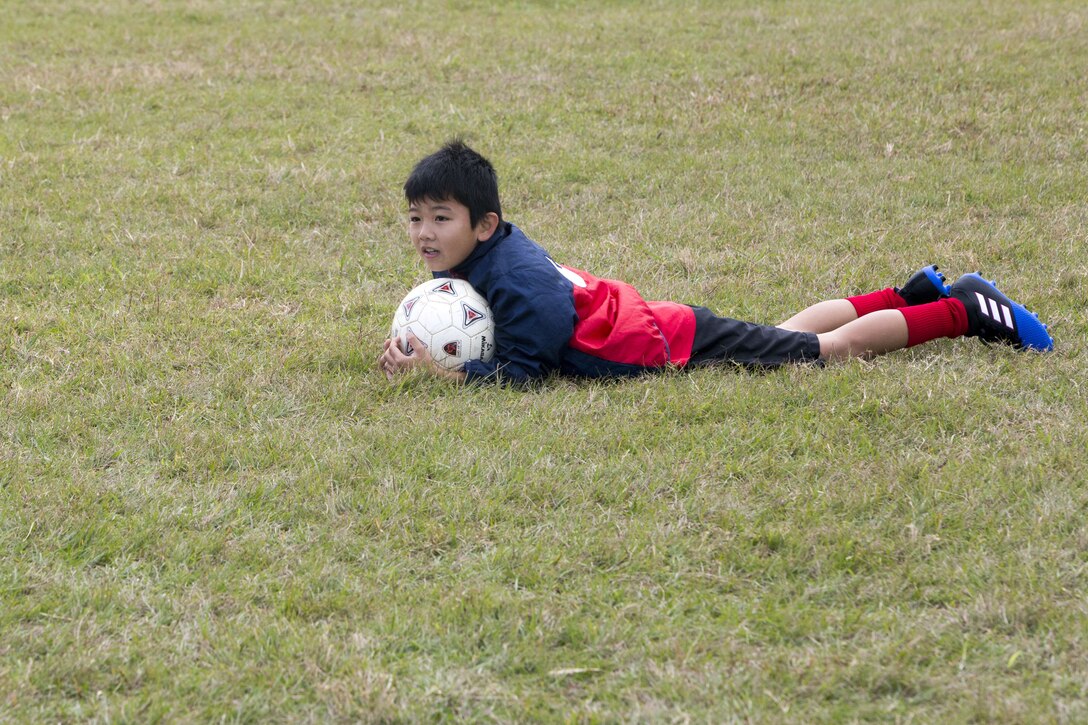 A child watches a soccer game at a six-on-six soccer tournament Jan. 6 aboard Camp Hansen, Okinawa, Japan. Marine Corps Community Services invited members of the local community to compete against Marines for the first place trophy. Winners from the top three teams were awarded T-shirts and gift cards to any MCCS facility.  (U.S. Marine Corps photo by Pfc. Nicole Rogge)