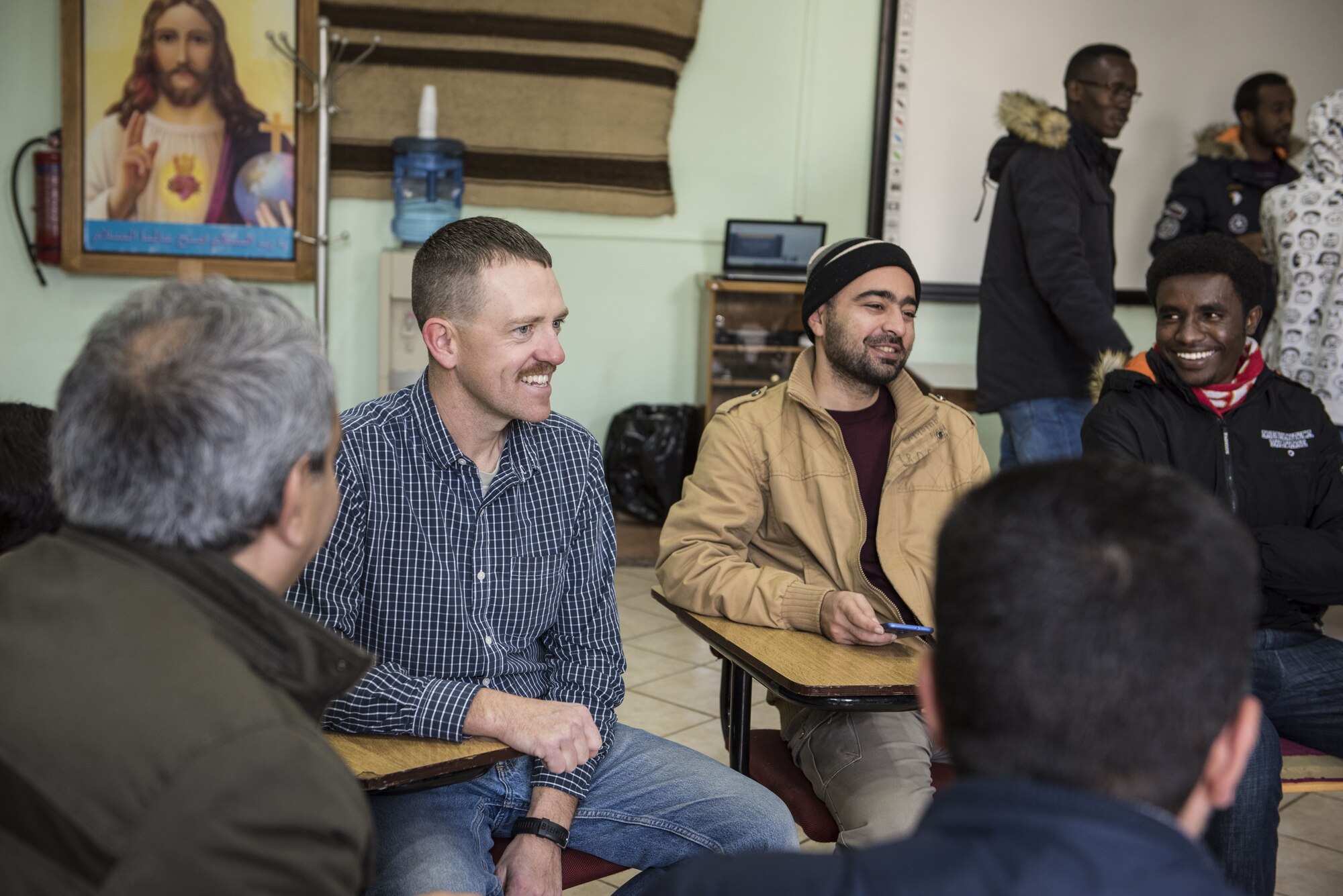 U.S. Air Force Master Sgt. Kelly Baker, from the 332d Expeditionary Civil Engineer Squadron, interacts with locals at a community center January 6, 2018 in Southwest Asia. Baker and other Airmen delivered clothing, books and supplies donated by service members deployed to an installation nearby. (U.S. Air Force photo by Staff Sgt. Joshua Kleinholz)