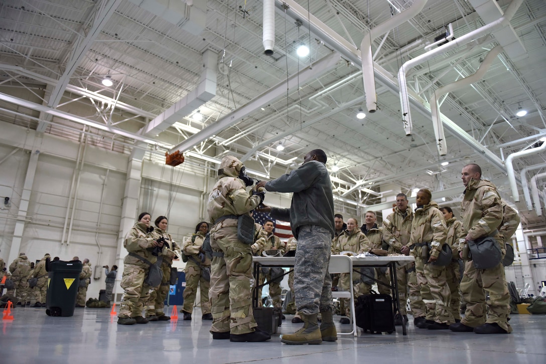 Tech. Sgt. Cornell Turrentine, center right, reviews the use of the gas mask drinking tube.