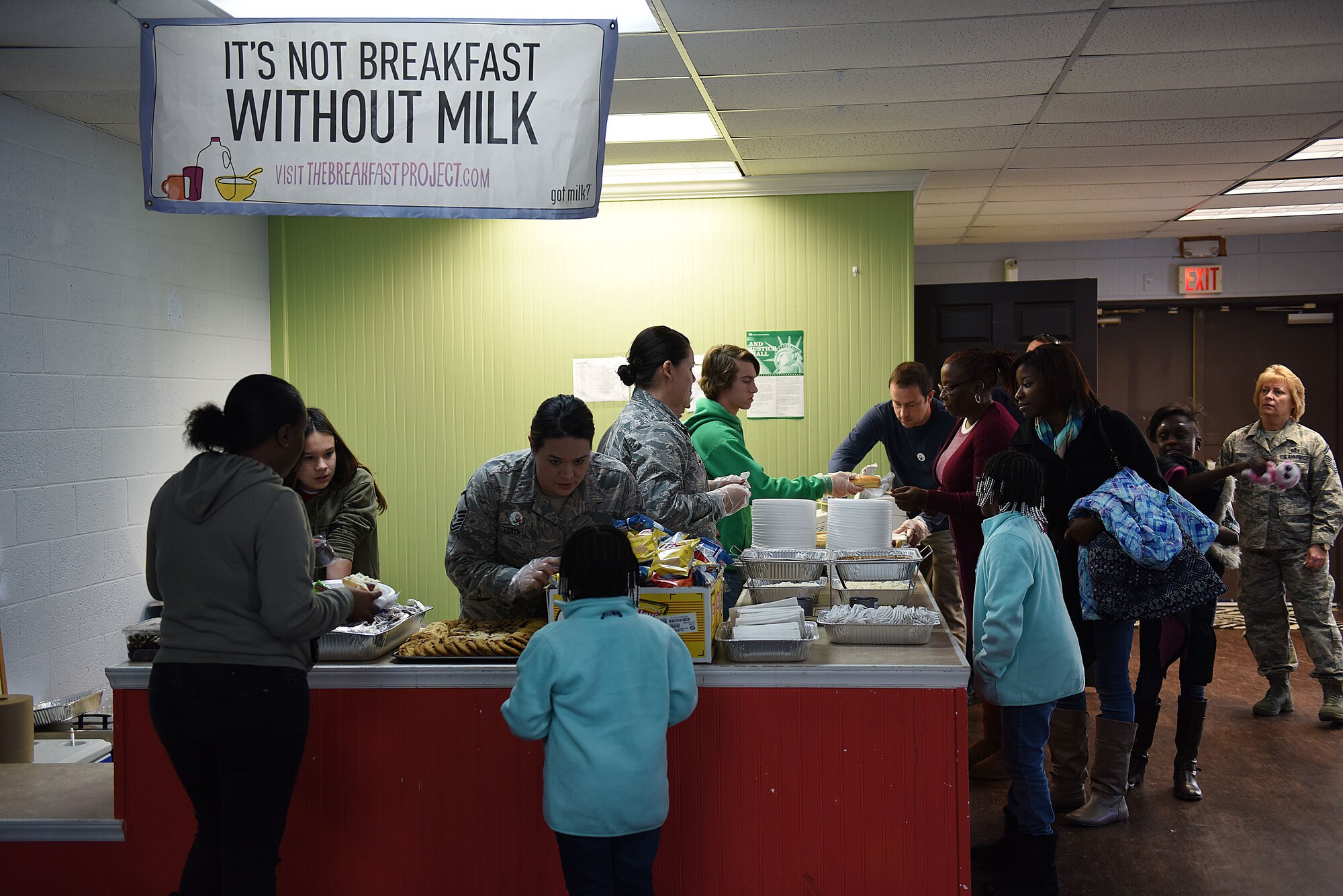 Members of the North Carolina Air National Guard (NCANG) serve food and drinks to families during Operation Santa at the Aristotle Preparatory Academy, Dec. 16, 2017. Operation Santa is a local and annual event run by the Chapter 7 organization of the North Carolina Air National Guard. This year, the NCANG provided presents, lunch, music, face-painting, blankets, stuffed animals. They partnered with the local Target for food donations and a craft table, and inflatable castles through Garris and Wilson Entertainment. (U.S. Air National Guard photo by Staff. Sgt. Laura J. Montgomery)