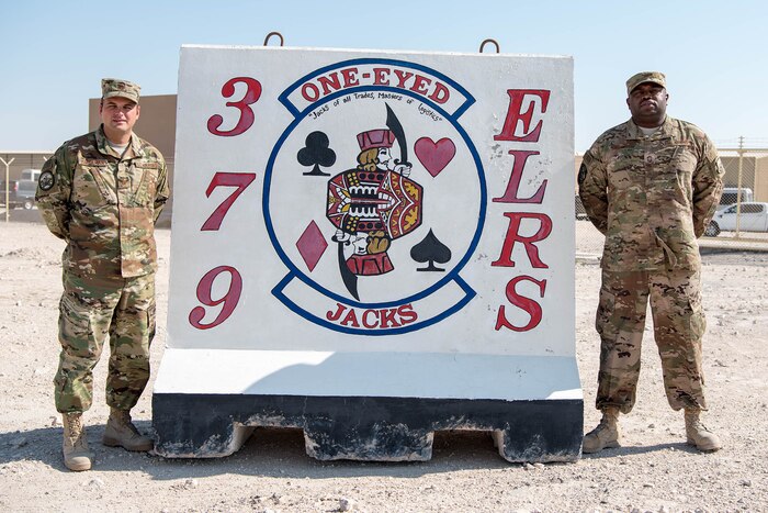 Two men stand next to a sign.