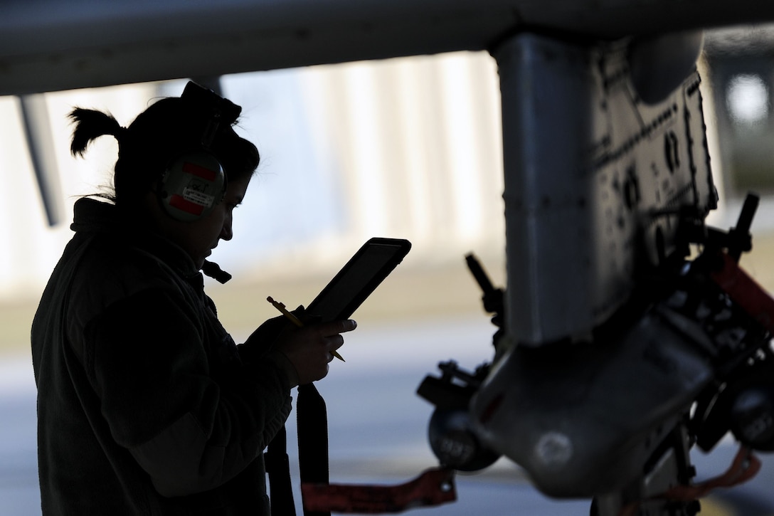 Aircraft maintenance airman reviews instructions on the flight line.