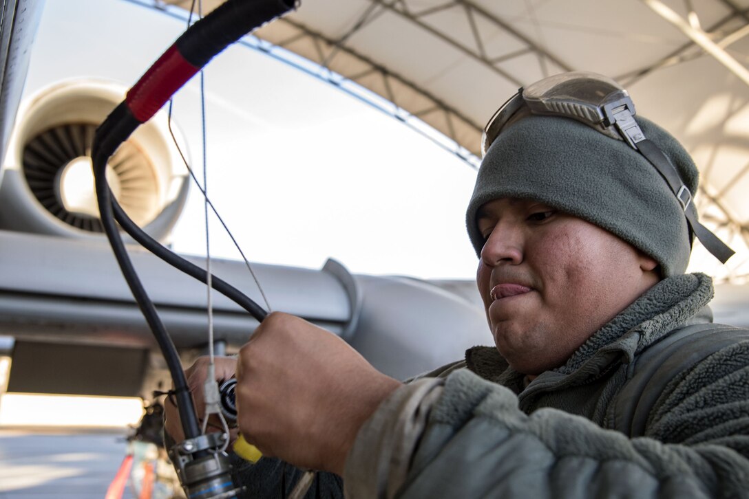 An airman connects a radio wire.