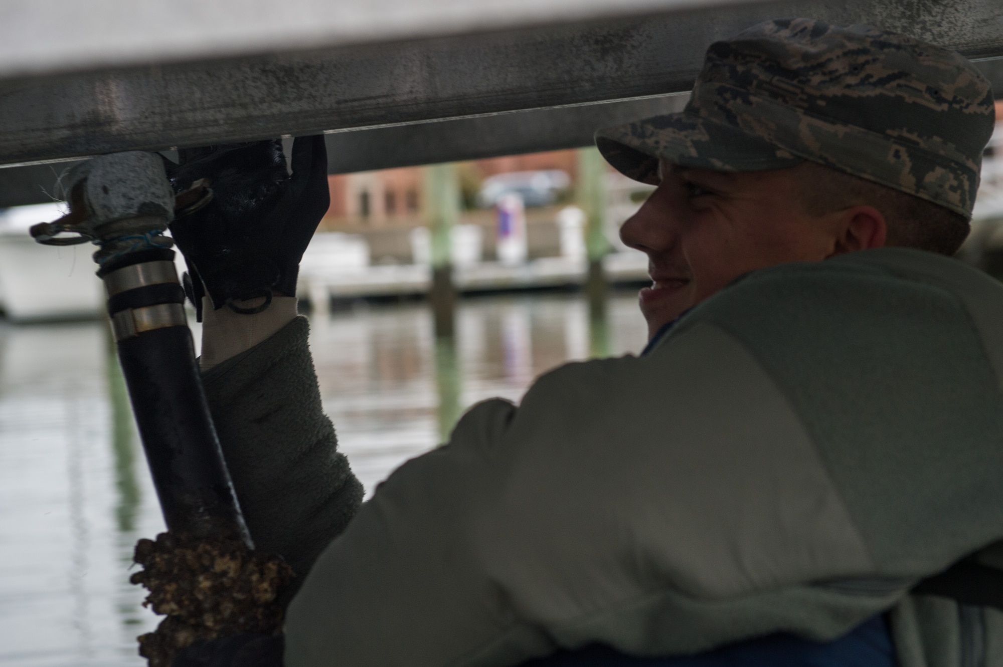 U.S. Air Force Airman 1st Class Tyler Talbot, 633rd Civil Engineer Squadron water and fuel systems maintenance journeyman, hangs an emptied water pipe under the Langley Marina docs at  Joint Base Langley-Eustis, Va., Dec. 7, 2017.