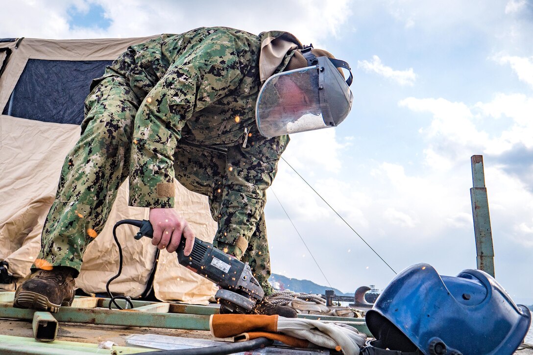 Navy Chief Jesse Hamblin repairs a ladder for an underwater pile removal operation.