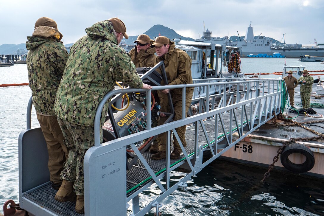 Navy Seabees move a divers water heater for an underwater pile removal operation.