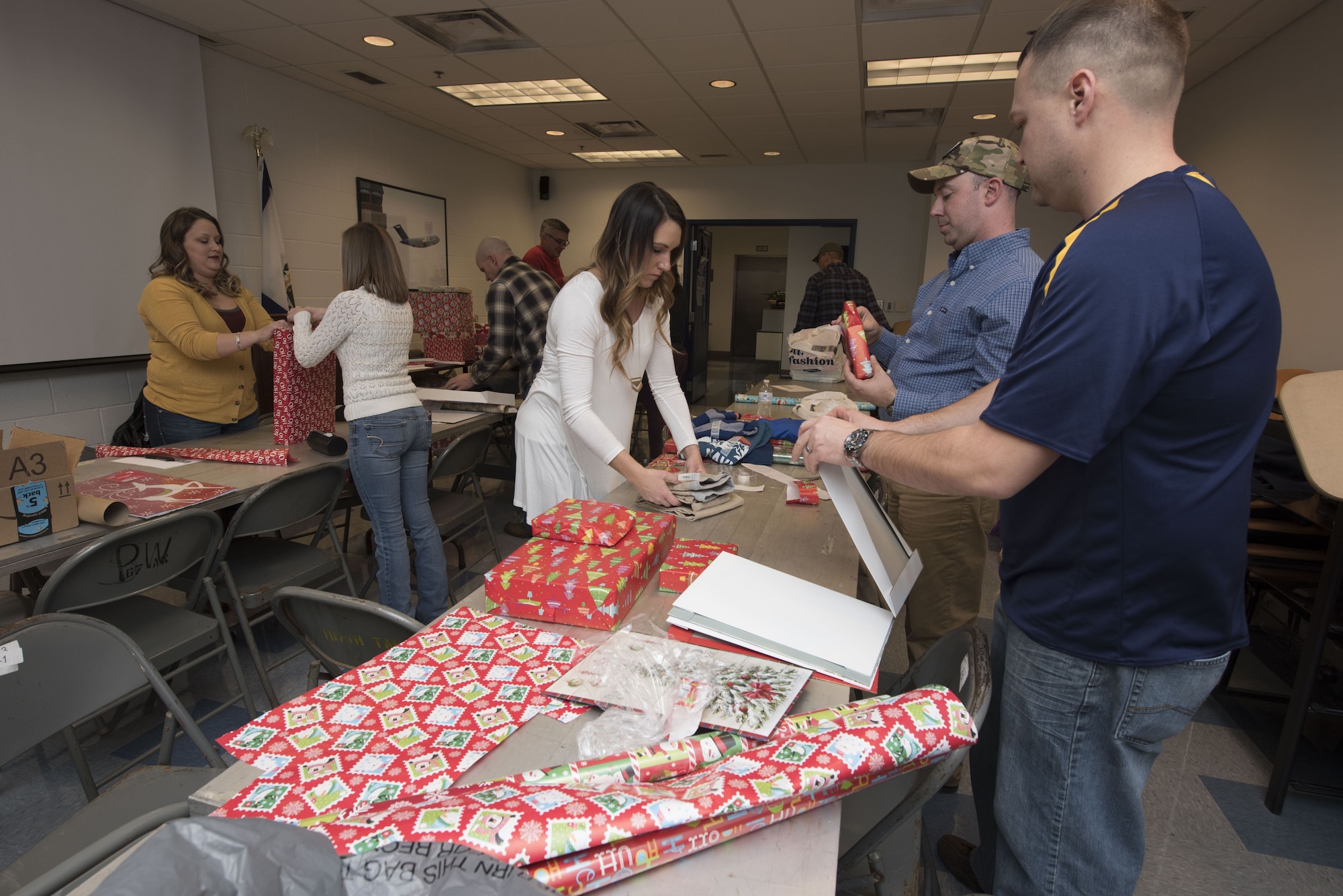Members of the 167th Operations Group wrap and organize gifts for children in the tri-county area as part of the Ops Adopts program headed up by First Lt. Ryan Day, a pilot for the 167th Airlift Wing, at far right in photo, in the Operations building at the 167th Airlift Wing, Martinsburg, W.Va., Dec. 15. (U.S. Air National Guard photo by Senior Master Sgt. Emily Beightol-Deyerle)
