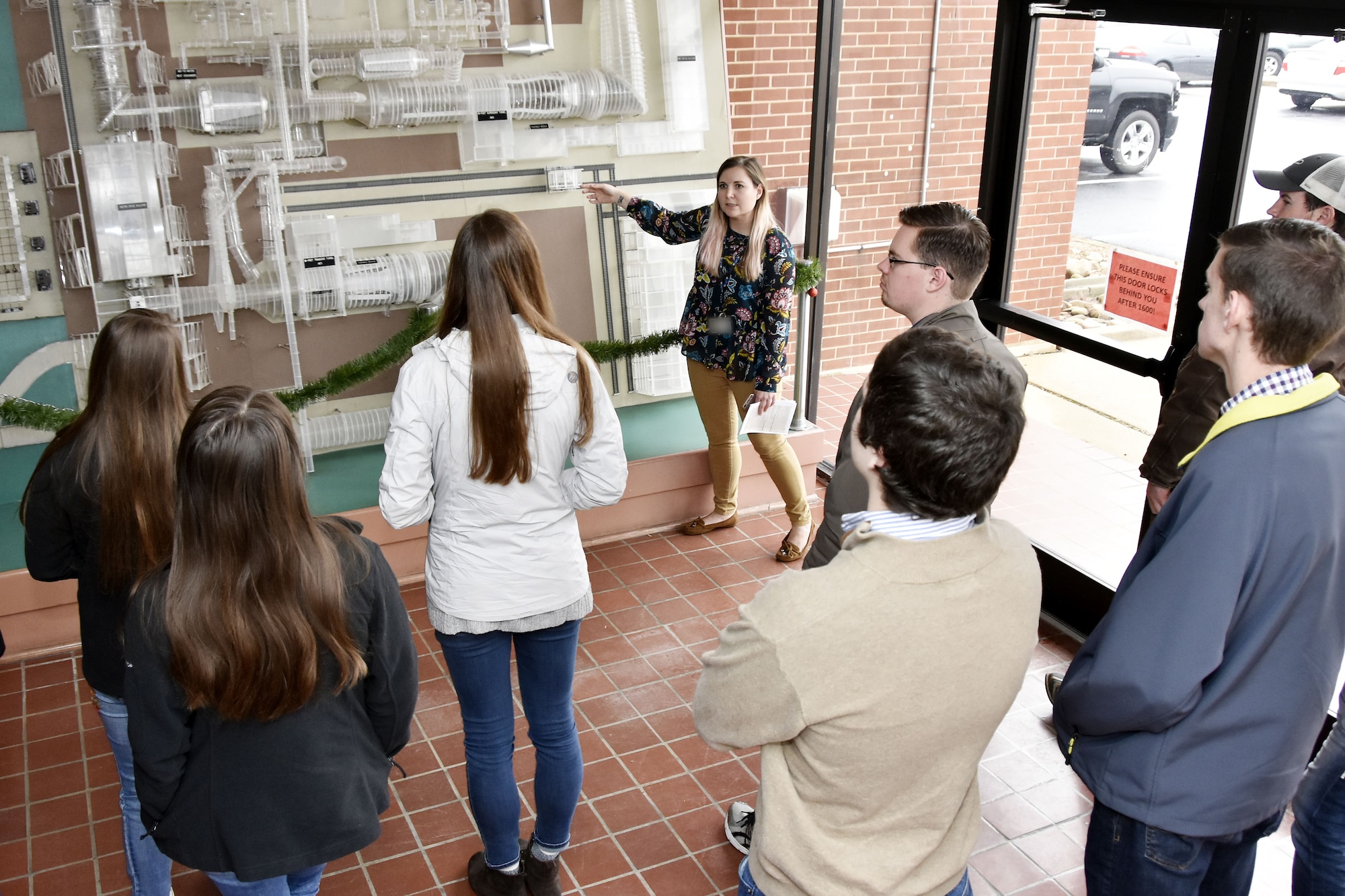 Deidre Ortiz, tour escort with the External Affairs and Communications Office, speaks to Bridge to the Future event participants at the Propulsion Wind Tunnel lobby during the tour portion of the day. The event Dec. 18 at Arnold Air Force Base provided college-age students of AEDC team members the chance to see where their family works and learn about the many career opportunities available. (U.S. Air Force photo/Rick Goodfriend)