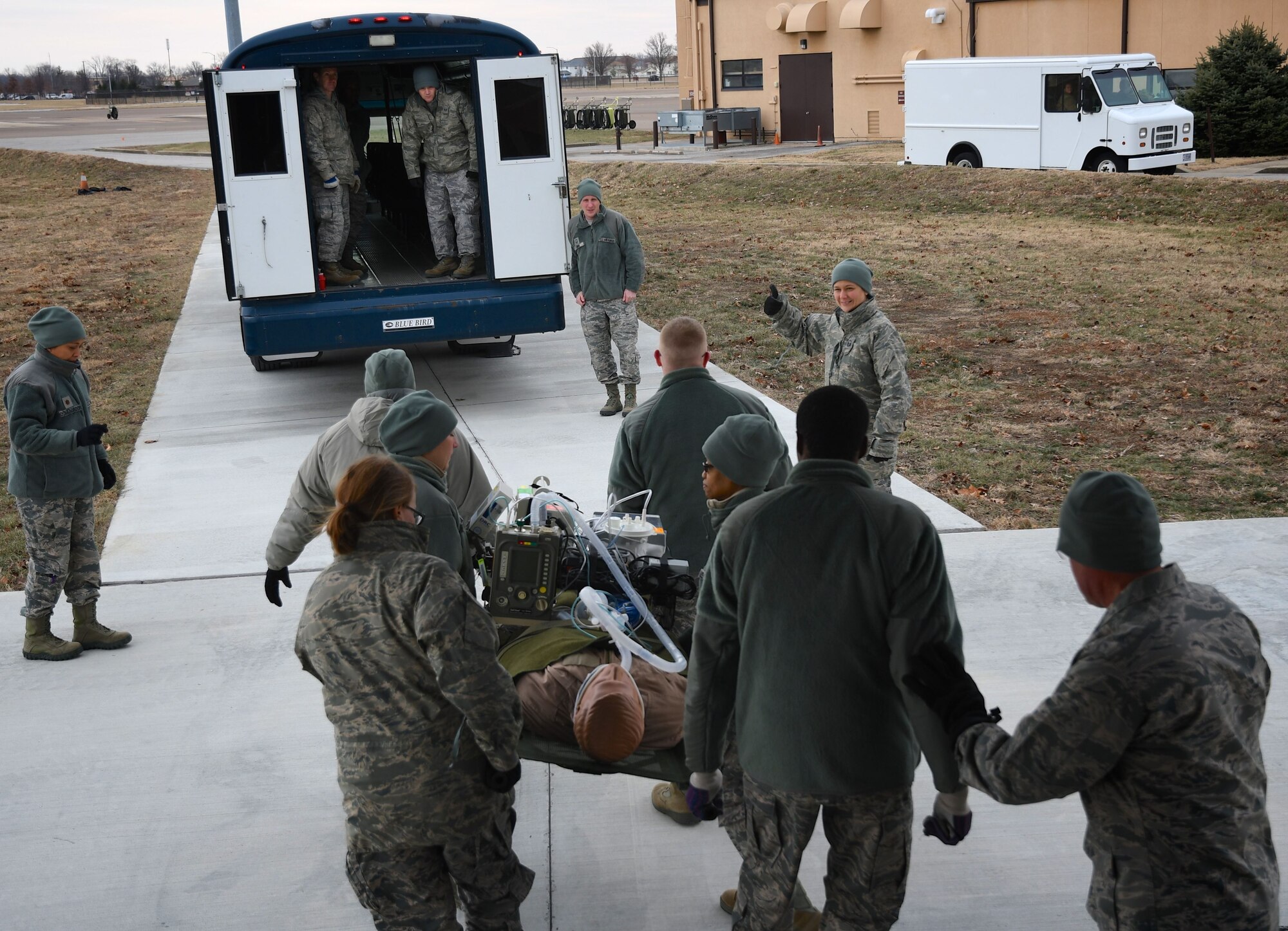 At upper right, Master Sgt. Aubrie Miskell gives the "thumbs up" sign and motions the next group of 932nd Aeromedical Staging Squadron (ASTS) members to move up with their litter, and load a bus for patient movement. The 932nd Airlift Wing worked improving and refining skills at the unit during the very cold Unit Training Assembly Jan. 7, 2018, at Scott Air Force Base, Ill. The 932nd Medical Squadron, 932nd Aeromedical Evacuation Squadron and 932nd Aeromedical Staging Squadron Airmen learned together on first aid skills and C-130 load checks. Simulated patients were moved safely on to a waiting bus, and then out to the aeromedical crew at the C-130 simulator. The compact, highly-packed training was designed to lead people and execute any future medical missions.  (U.S. Air Force photo by Lt. Col. Stan Paregien)