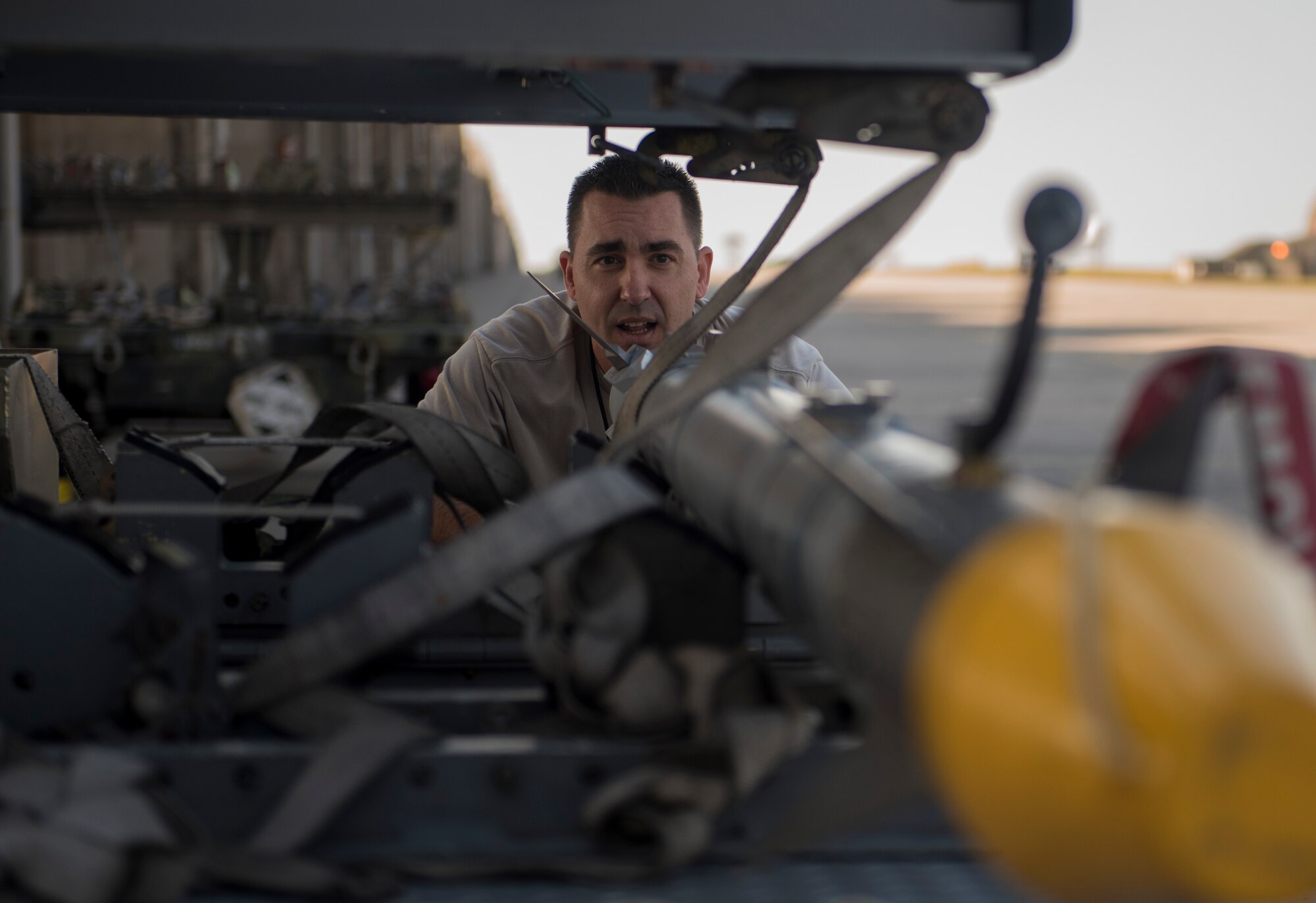 U.S. Air Force Chief Master Sgt. Davick Hansen, 18th Equipment Maintenance Squadron superintendent, inspects an AIM-9X heat seeking missile during the Chiefs versus Eagles Weapons Load competition Jan. 3, 2018, on Kadena Air Base, Japan. The competition pitted a team of chief master sergeants against a team of colonels to determine which group could prepare the aircraft for combat the fastest with the fewest procedural errors. (U.S. Air Force photo by Staff Sgt. Micaiah Anthony)