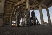 U.S. Air Force Airmen from the 44th Aircraft Maintenance Unit, stand at attention after loading munitions onto an F-15 Eagle during an annual weapons load competition Jan. 3, 2018, on Kadena Air Base, Japan. Airmen from the 44th AMU won the competition against Airmen from the 67th AMU. (U.S. Air Force photo by Staff Sgt. Micaiah Anthony)