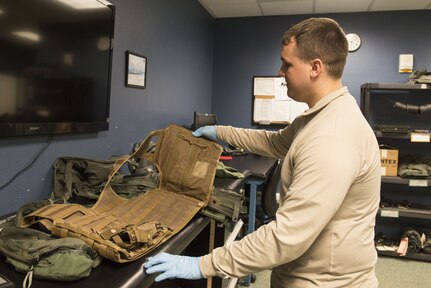 Airman 1st Class Conner Scott, an aircrew flight equipment journeyman with the 3rd Operations Support Squadron, inspects the new vests worn by pilots to ensure no wear or tears at Joint Base Elmendorf-Richardson, Alaska, Jan. 5, 2018. The new vests were designed to be more durable and provide pilots with the capabilities to adjust to fit individual needs and sizes.