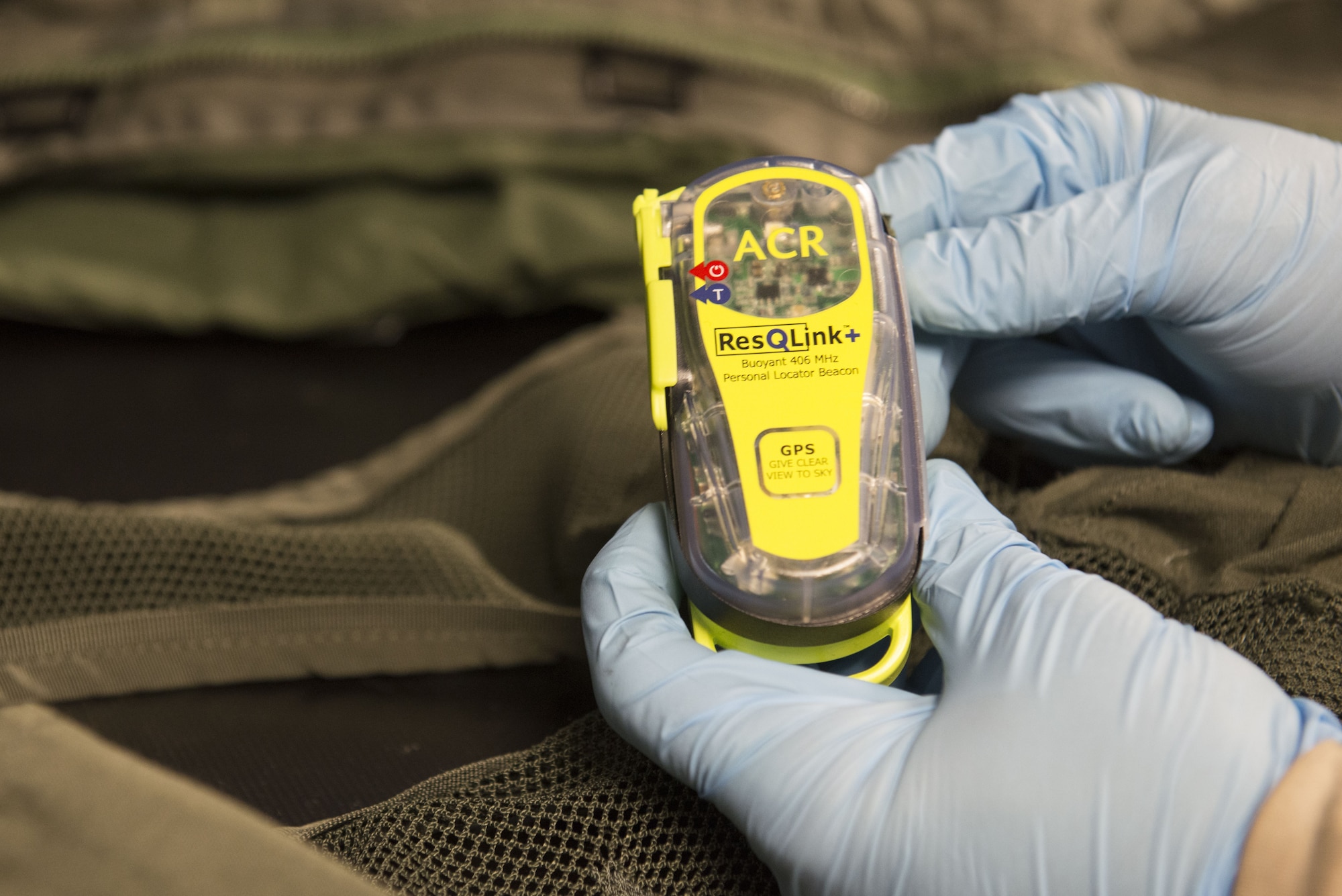 Airman 1st Class Conner Scott, an aircrew flight equipment journeyman with the 3rd Operations Support Squadron, ensures a personal locator beacon is operable at Joint Base Elmendorf-Richardson, Alaska, Jan. 5, 2018. A PLB will send out an emergency distress signal alerting nearby search and rescue when activated.