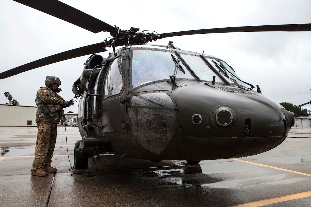 Sgt. Matthew Gryzwa prepares a UH-60 Black Hawk helicopter for takeoff.