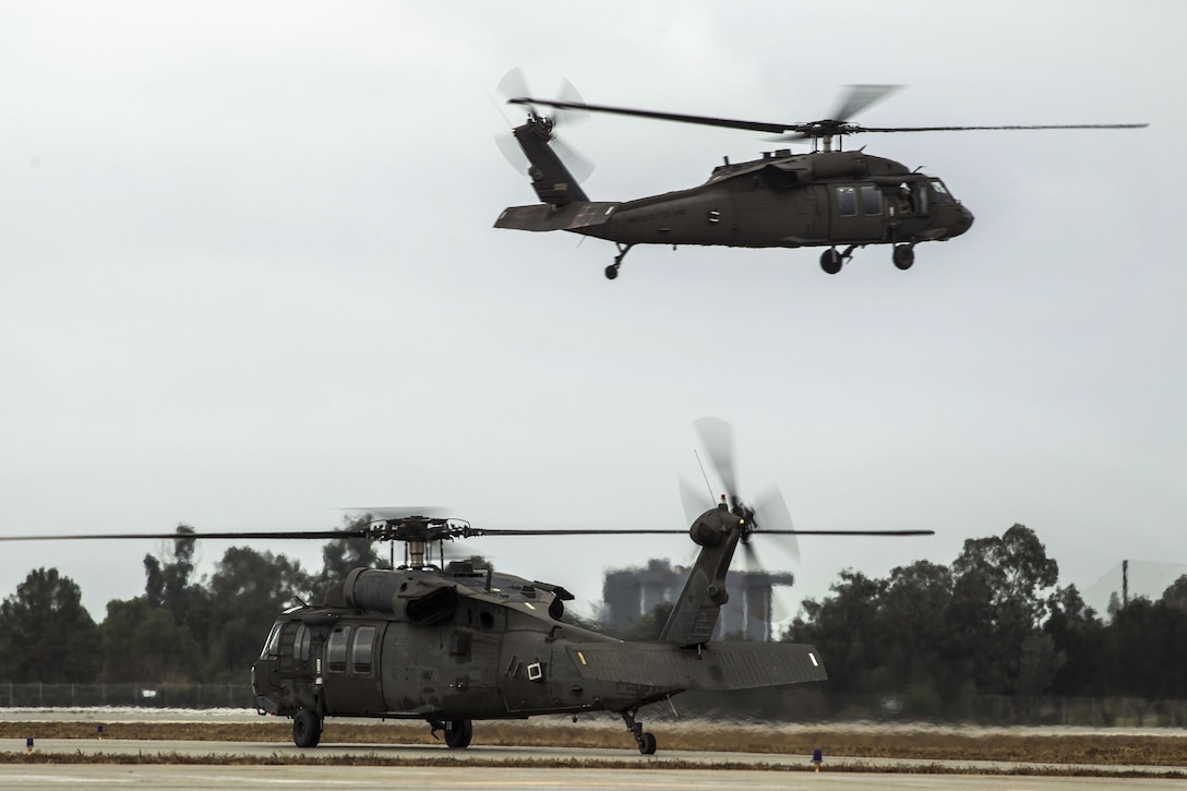 Two California Army National Guard UH-60 Black Hawk helicopters take off.