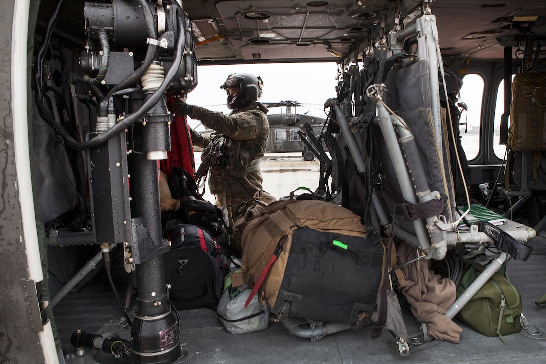 Sgt. Matthew Gryzwa prepares a UH-60 Black Hawk helicopter for takeoff to test its new rescue hoist system.