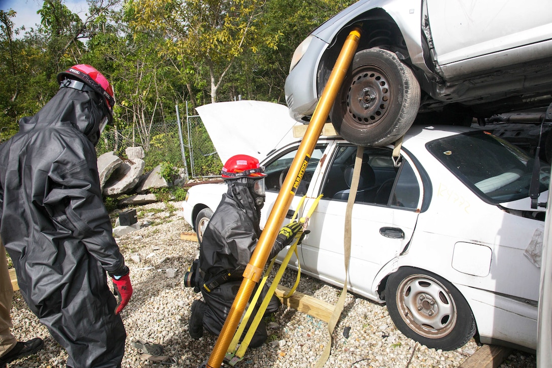 Army Reserve soldiers attach straps to a damaged vehicle during training.