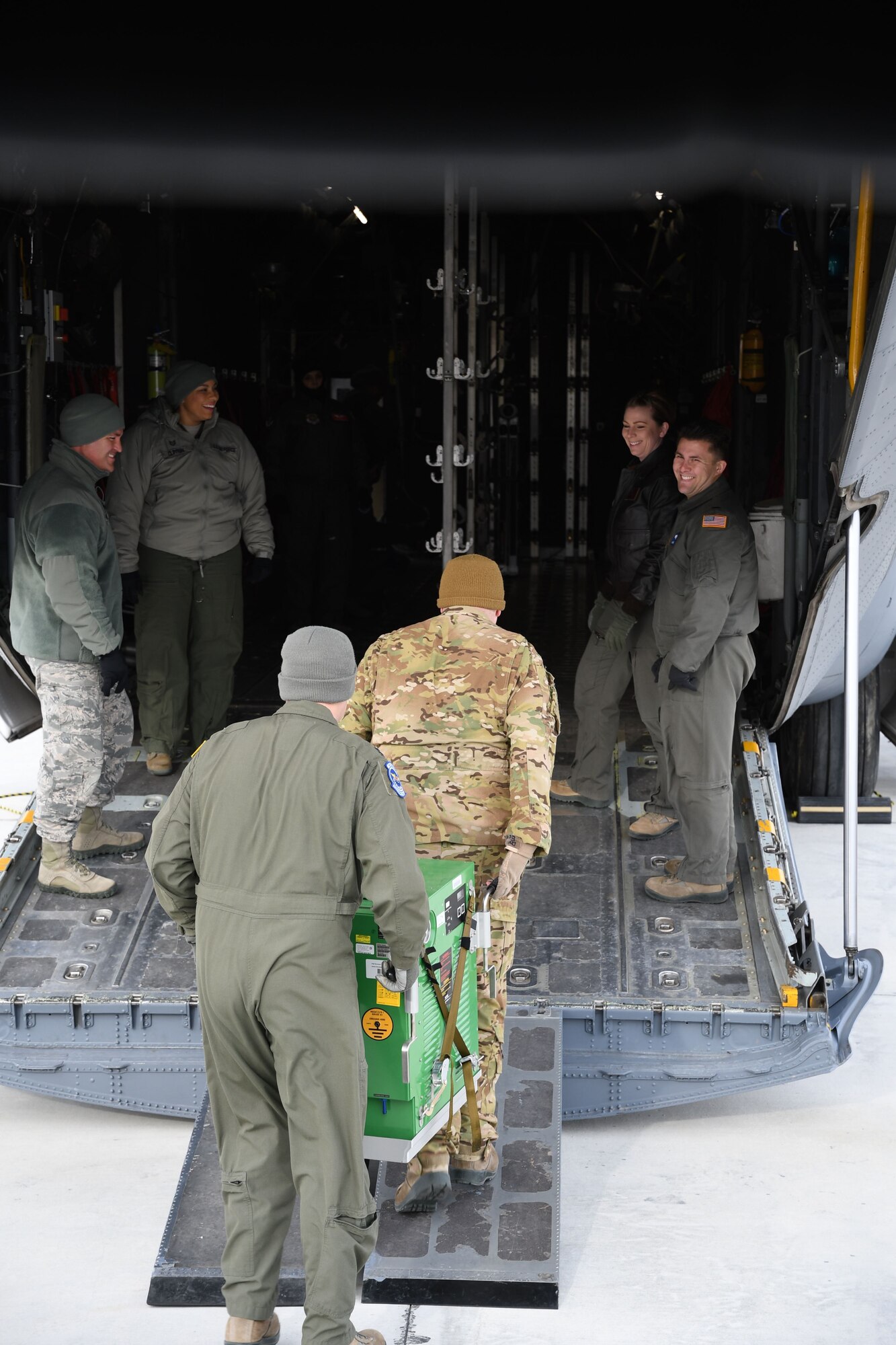 Despite the frigid January temperatures, a group of 932nd Aeromedical Evacuation Squadron (AES) and 932nd Aeromedical Staging Squadron (ASTS) members offload equipment from an equipment truck to to move up the ramp of the C-130 simulator on Jan. 7, 2018, at Scott Air Force Base, Ill.  The 932nd Airlift Wing worked improving and refining skills at the unit during the cold Unit Training Assembly.  The Airmen worked together on first aid skills and C-130 load checks. Simulated patients were moved safely on to a waiting bus, and then out to the aeromedical crew at the C-130 simulator. The compact, highly-packed training was designed to lead people and execute any future medical missions.  (U.S. Air Force photo by Lt. Col. Stan Paregien)