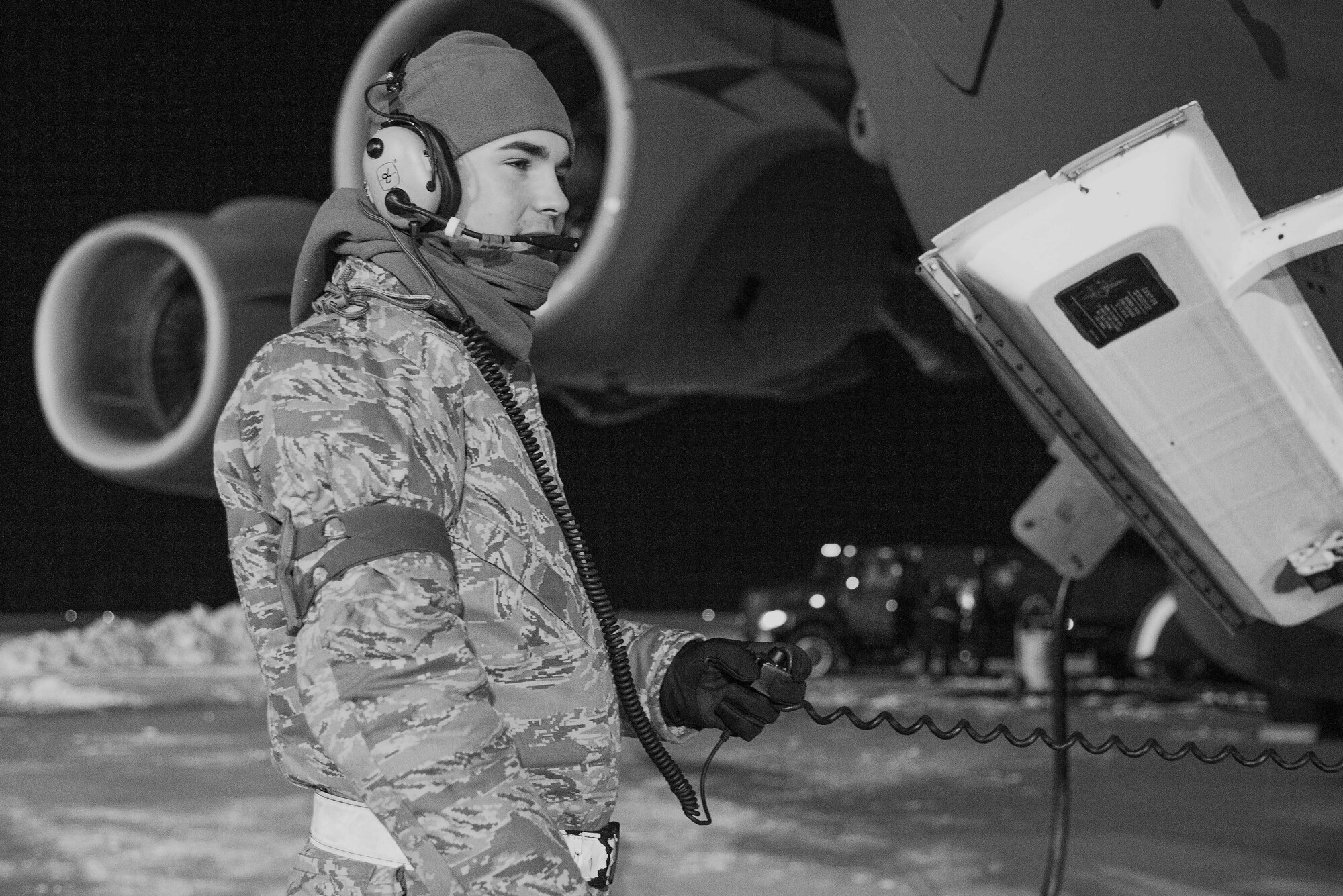 Senior Airman Garrett Battle, 736th Aircraft Maintenance Squadron communication and navigation journeyman, stands near the nose of a C-17A Globemaster III as the aircraft is being refueled, Jan. 5, 2018, at Dover Air Force Base, Del. Battle and other 736th AMXS maintainers prepared the aircraft for a mission in temperatures in the low teens and blowing snow from a steady 15 mile per hour wind. (U.S. Air Force photo by Roland Balik)