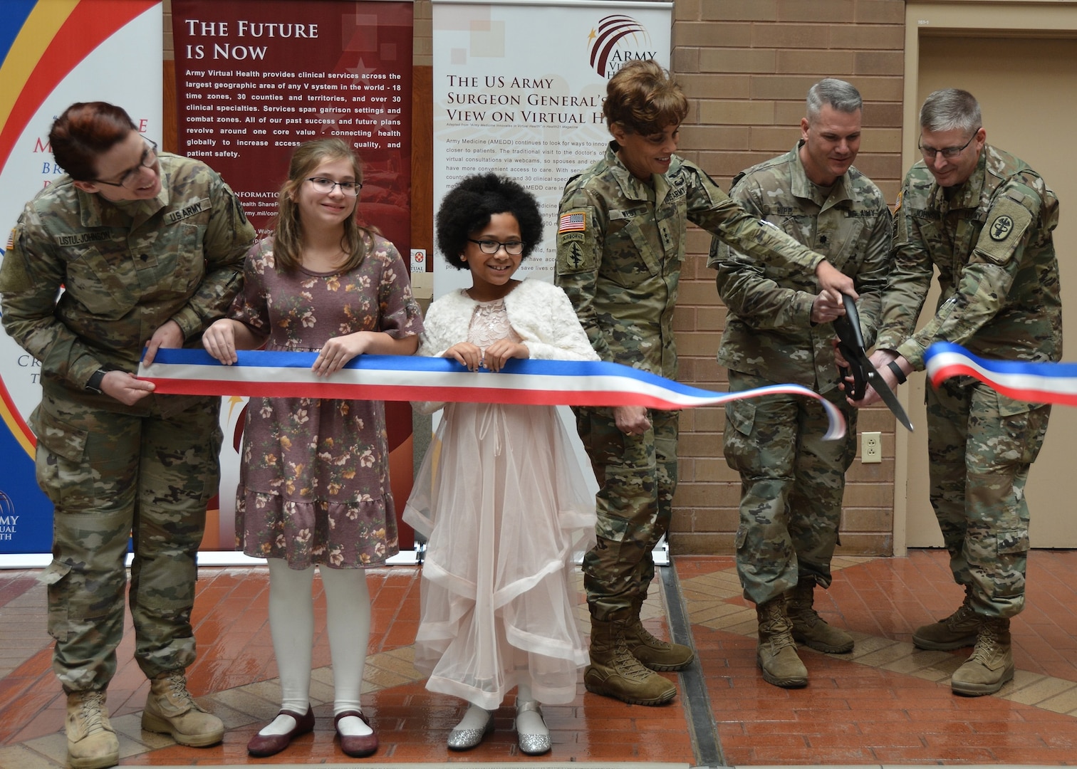 (From left) Lt. Gen. Nadja West, Armyhe Surgeon General and commanding general , U.S. Army Medical Command; Brig. Gen. Jeffrey Johnson, Brooke Army Medical Center commanding general, Lt. Col. Sean Hipp, director of the Army Virtual Medical Center, and children from Fort Sam Houston Elementary School cut the ribbon during the Army Virtual Health Kickoff ceremony Jan. 4.