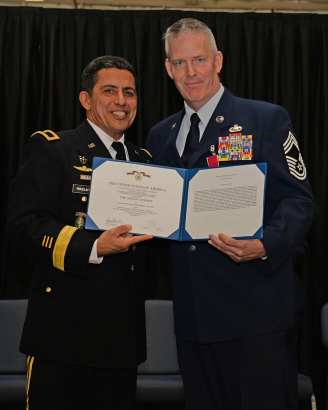The Adjutant General, New Hampshire National Guard Brig. Gen. David J. Mikolaities, presents the Legion of Merit certificate to Chief Master Sgt. Matthew J. Collier during a ceremony at Pease Air National Guard Base, N.H., Jan. 6, 2017.  Collier retired after 36 years of combined service in the U.S. Air Force and ANG. (N.H. Air National Guard photo by Staff Sgt. Curtis J. Lenz)