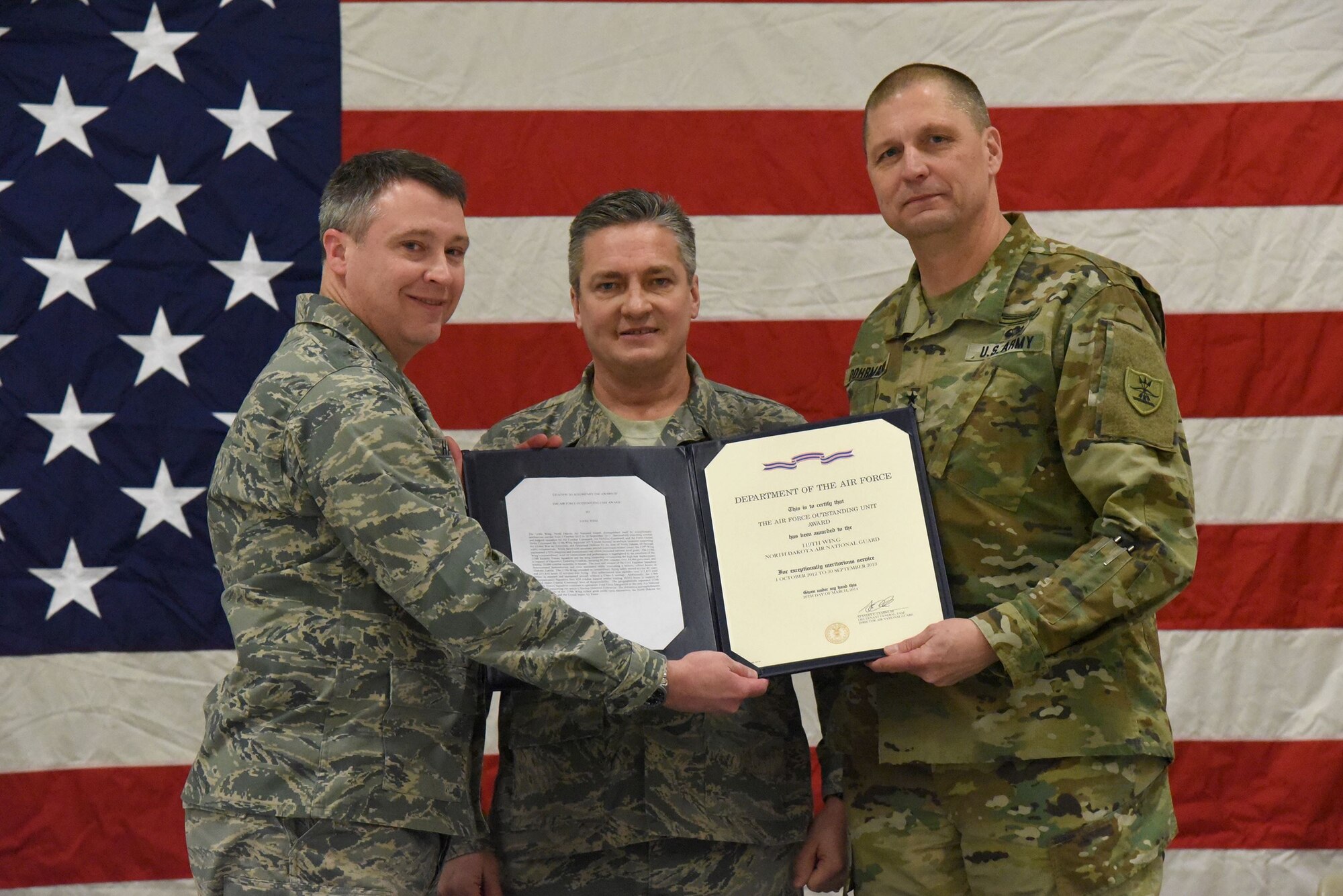 From left to right Col. Britt Hatley, the 119th Wing commander, Chief Master Sgt. Duane Kangas, the 119th Wing command chief, and Maj. Gen. Al Dohrmann, the North Dakota adjutant general, hold the Air Force Outstanding Unit Award certificate during a ceremony at the North Dakota Air National Guard Base, Fargo, North Dakota, Jan. 6, 2018.