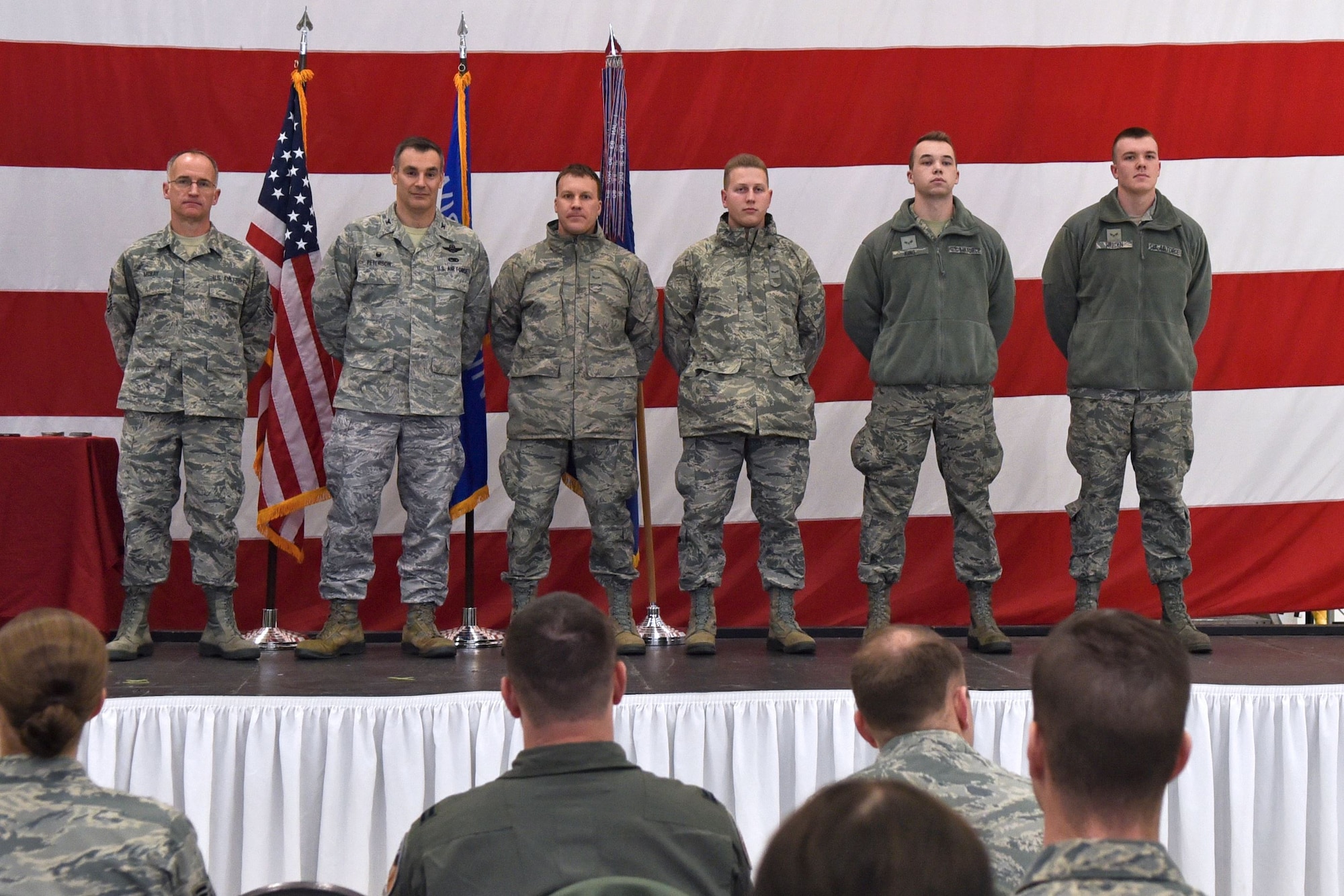 Command Chief Master Sgt. James McKay (left) joins 115th Fighter Wing Commander Col. Erik Peterson to recognise new unit members who earned the title of honor graduate in Basic Military Training during the unit's annual awards ceremony at Truax Field in Madison, Wisconsin, Jan. 6, 2017. The ceremony highlighted Airman from throughout the unit who displayed exemplary skill and leadership in the performance of their duties both at home, and in deployed locations around the world. (U.S. Air National Guard photo by Tech. Sgt. Andrea Rhode)