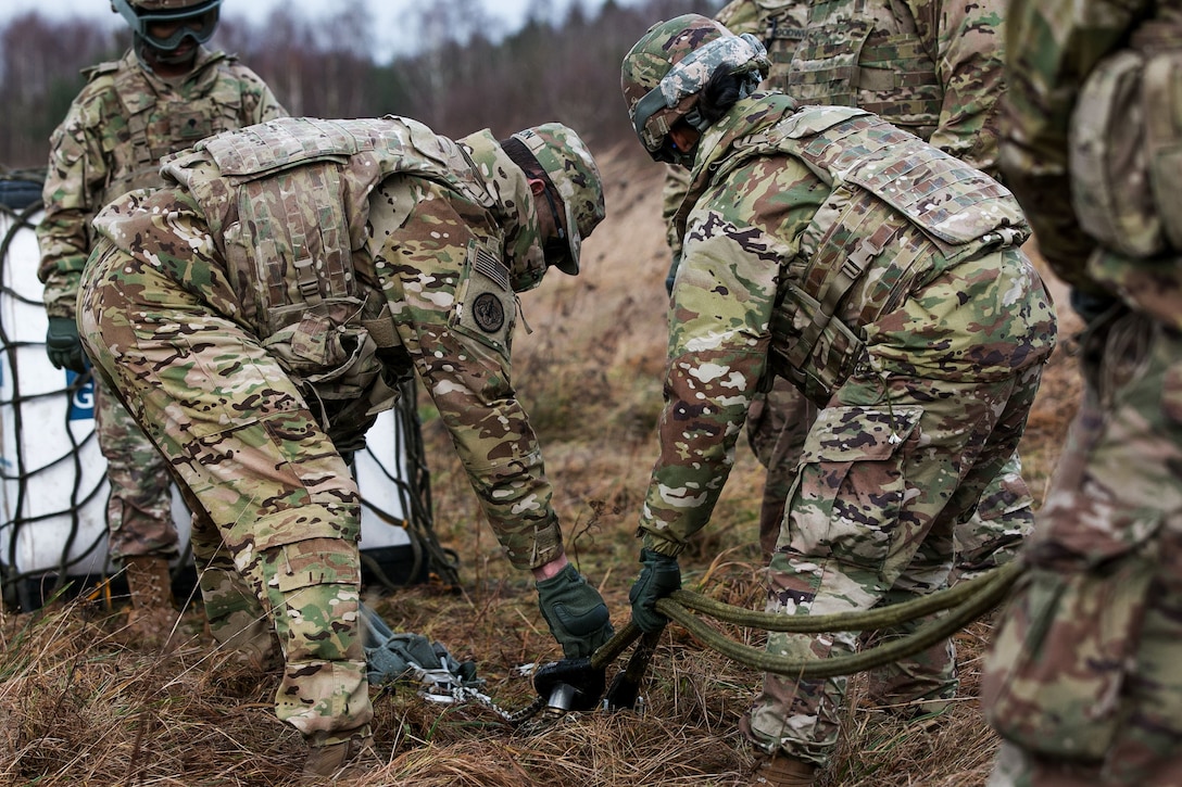 Soldiers assigned to the 299th Brigade Support Battalion, 2nd Brigade Combat Team, 1st Infantry Division, Fort Riley, Kansas, prepare equipment during helicopter slingload operations in Skwierzyna, Poland.