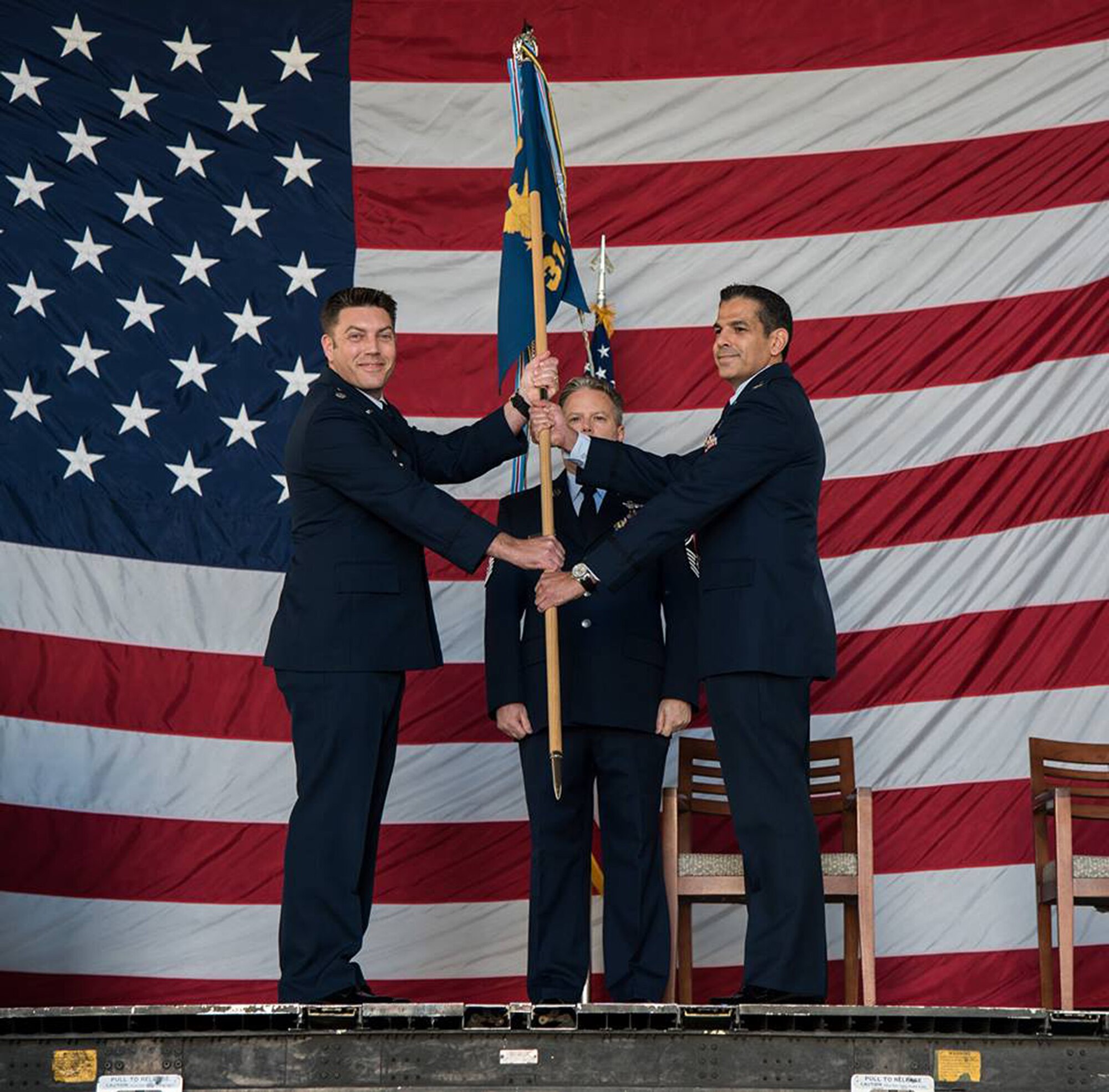 Lt. Col. Ricardo Hiraldo (right), 312th Airlift Squadron commander, accepts the guidon from Lt. Col. Travis Rowley (left), 349th Operations Group commander, during an assumption of command ceremony at Travis Air Force Base, Calif., on Jan. 6, 2018.