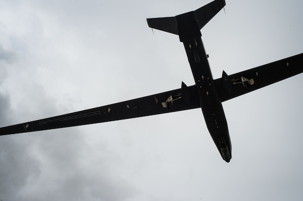 An RQ-4 Global Hawk descends during a landing after completing a sortie in support of Operation Inherent Resolve at an undisclosed location in Southwest Asia, Feb. 20, 2017. During the landing a chase car, operated by an RQ-4 Global Hawk pilot, assisted in the landing of the remotely piloted aircraft. (U.S. Air Force photo/Senior Airman Tyler Woodward)