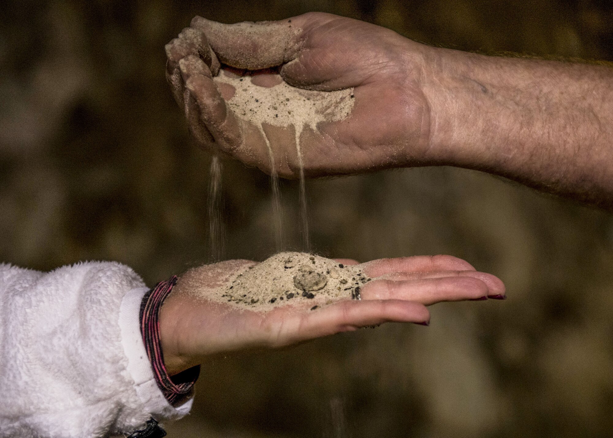 Don Marson, Crystal City Underground tour guide, pours sand into a guest’s hand as he explains the history of the abandoned, submerged sandstone mine, Oct. 21, 2017, at Crystal City Underground in Crystal City, Mo. Marson hosts underground kayaking trips from Scott Air Force Base Outdoor Recreation each month. (U.S. Air Force photo by Airman 1st Class Tara Stetler)