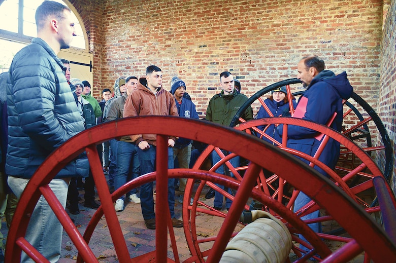 Marines surround Brad Gerstbrein, course director, MCU-USMC College of Distance Education and Training as he describes the events which transpired in the engine house which abolitionist John Brown took his final stand against 90 Marines.