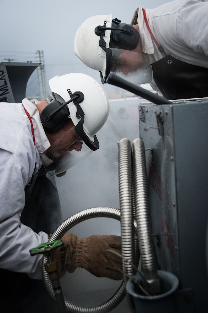 U.S. Air Force Tech. Sgt. Eric Fortenberry (left) and U.S. Air Force Airman 1st Class Jerry Timmons, 673d Logistics Readiness Squadron fuels facilities technicians, take a sample of liquid oxygen at Joint Base Elmendorf-Richardson, Alaska, Dec. 4, 2017. Oxygen is pressurized and cooled into a liquid state in order to transport it more efficiently from cryogenic tanks to JBER’s aircraft to provide fresh air to pilots in flight.