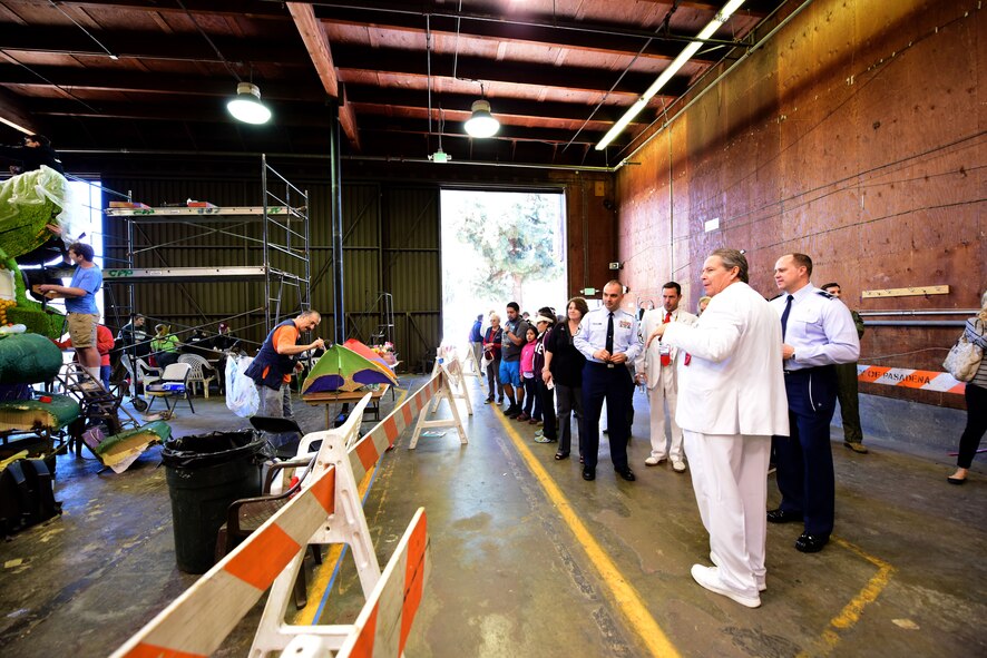 UA Tournament of Roses representative dressed in a white suit shows 509th Bomb Wing leadership one of the Decorating Places for Rose Parade floats in Pasadena, Calif., Dec. 30, 2017. The Decorating Places is a designated work area for volunteers to apply the final touches of seeds, bark, grasses and flowers to their float before the parade on New Year’s. (U.S. Air Force photo by Staff Sgt. Danielle Quilla)