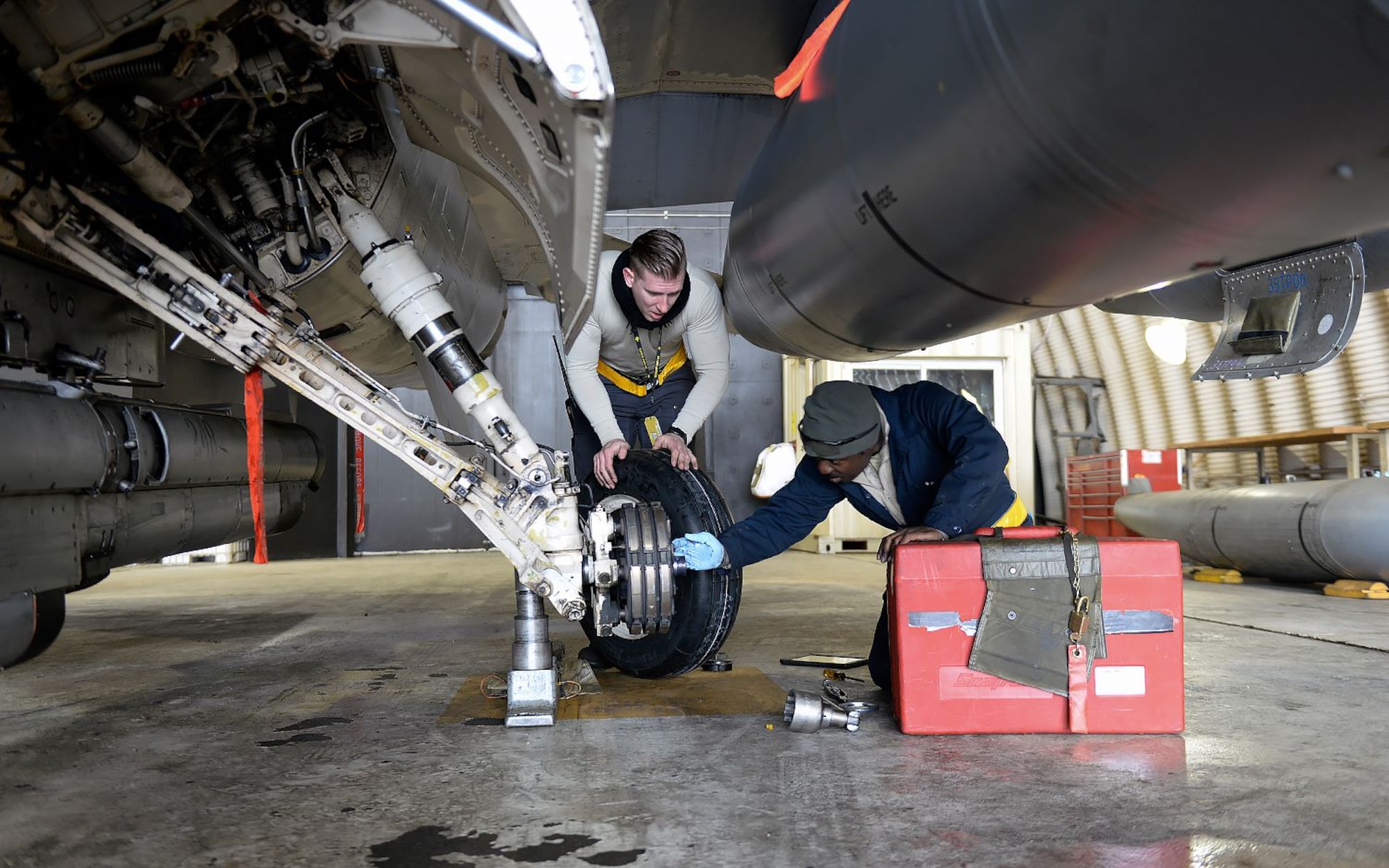 U.S. Air Force Staff Sgt. William Horne and Senior Airman Isiah Bishop, 80th Fighter Squadron crew chiefs, change a left main-tire Jan. 10, 2018, at Kunsan Air Base, Republic of Korea. The crew chiefs and maintainers who work on swing shift to keep the 80th Fighter Squadron mission ready have a saying that reminds them no matter the weather condition, they have a job to do, and they'll “do it better than you." (U.S. Air Force photo by Senior Airman Colby L. Hardin)