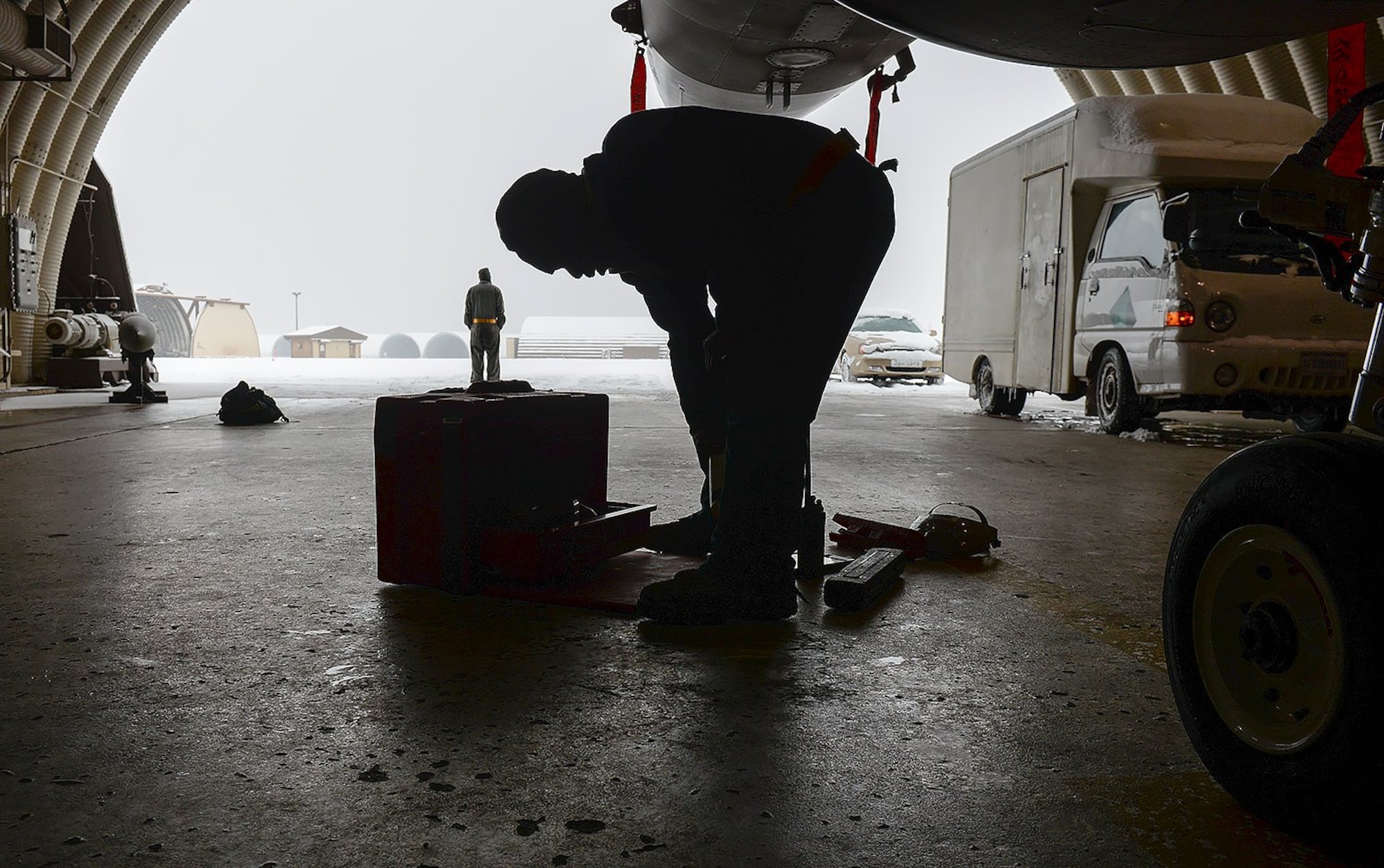U.S. Air Force Senior Airman Isiah Bishop, 80th Fighter Squadron crew chief, looks through his tool-kit during a tire change Jan. 10, 2017, at Kunsan Air Base, Republic of Korea. The Airmen continue the mission despite the dramatic snowfall received on the flightline. (U.S. Air Force photo by Senior Airman Colby L. Hardin)