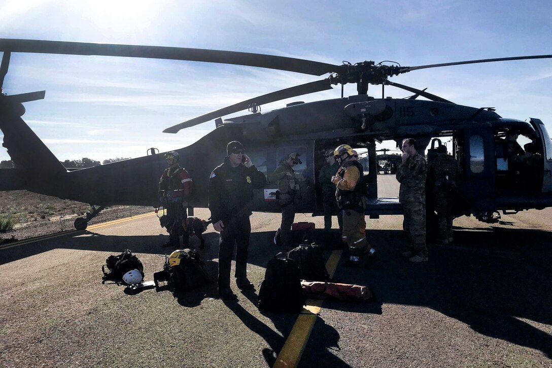 California Air National Guardsmen and pararescuemen prepare their gear before taking off in a HH-60G Pave Hawk rescue helicopter.