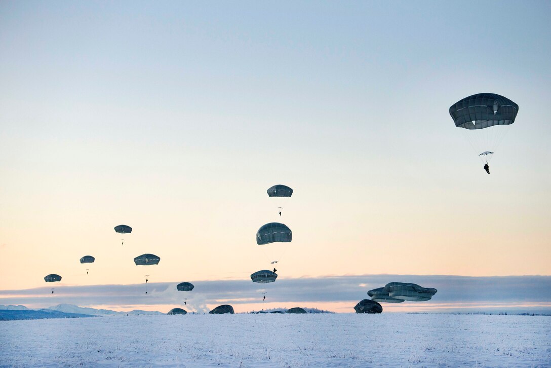 Soldiers descend over Malemute drop zone during airborne training.