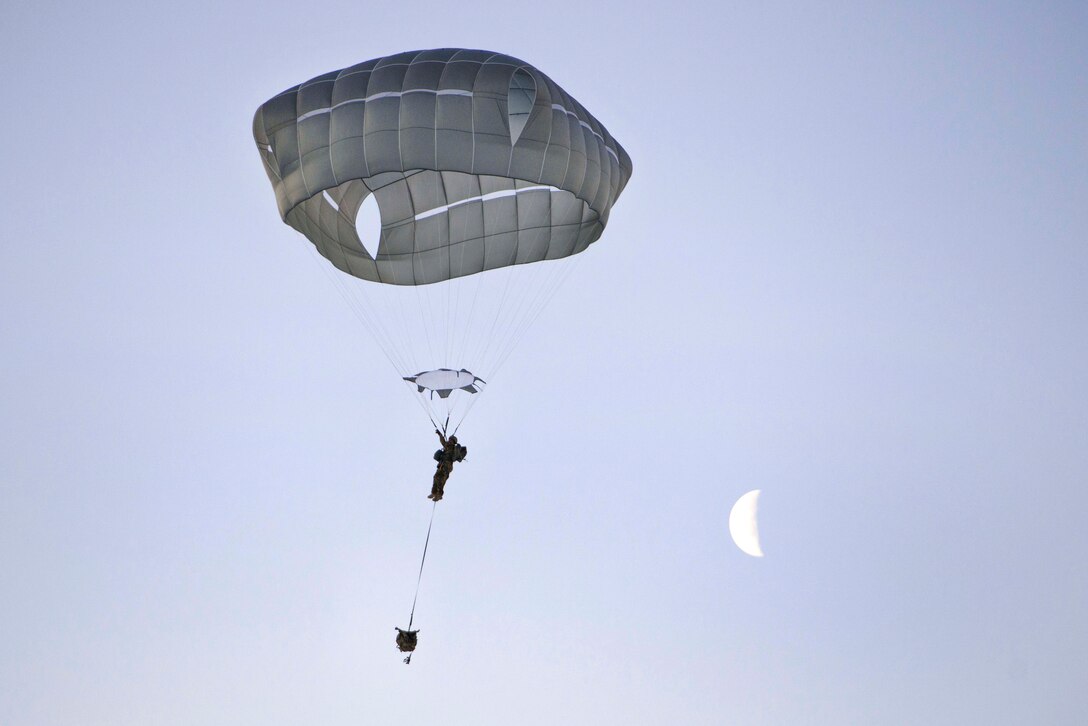 A soldier descends over Malemute drop zone during airborne jump training.