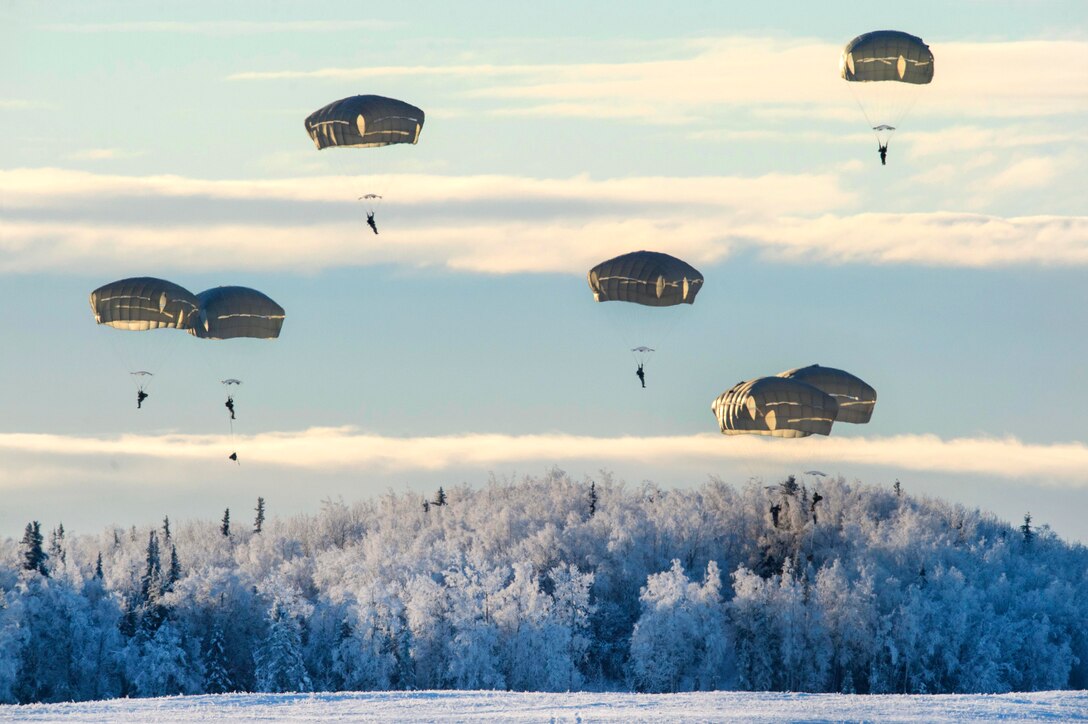 Soldiers descend over Malemute drop zone during airborne training.