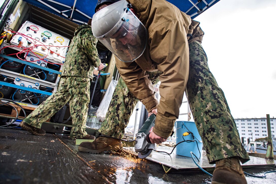 Petty Officer 2nd Class Sean McHugh repairs a ladder during an underwater pile removal operation.