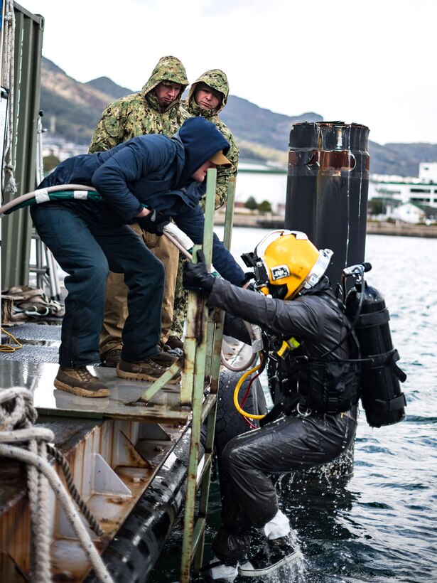 Navy Seabees and divers participate in an underwater pile removal operation.