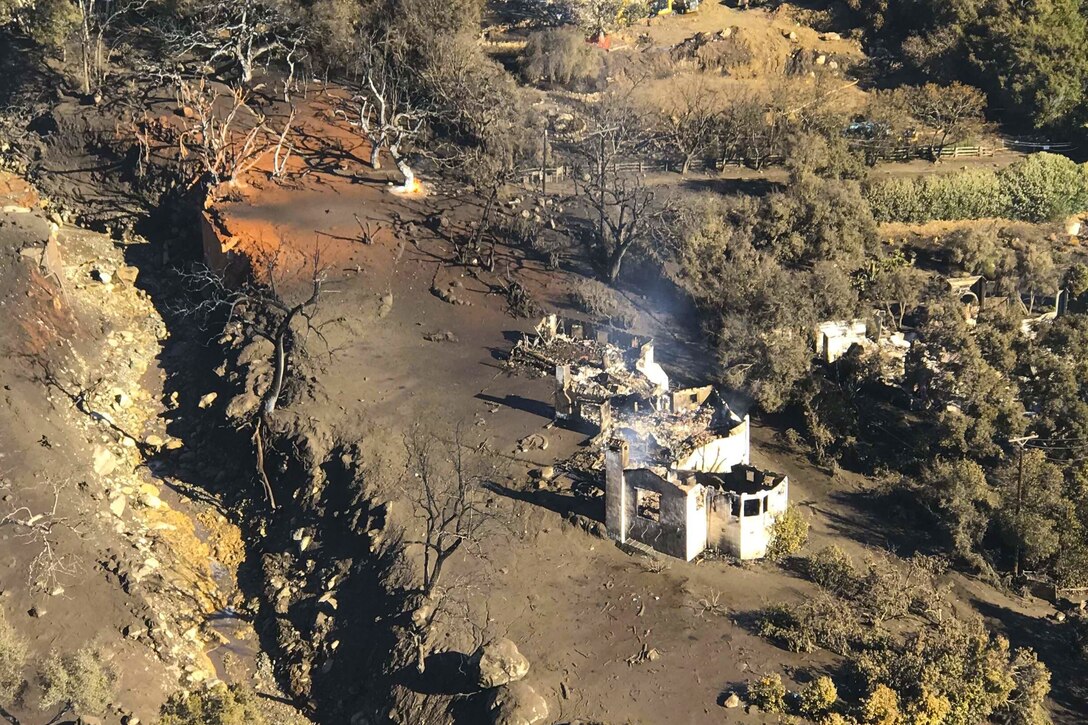 A home is destroyed and surrounded by mud from a mud slide.
