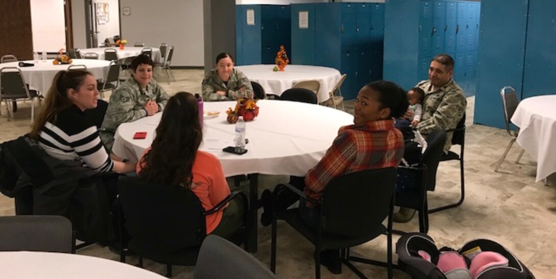 (From right to left) Maj. Jaime Hernandez, commander of the 28th Security Forces Squadron, holds the child of Senior Airman Tkeyah Charley, a response force member assigned to the 28th SFS, as he talks with a team of defenders about the idea of the Little Defender’s Den during a squadron event in the Base Defense Operations Center on Ellsworth Air Force Base, S.D., Nov. 17, 2017. The idea for the family room stemmed from Charley’s struggle with finding an adequate and comfortable place to use her breast pumps during the work day. (Courtesy photo)