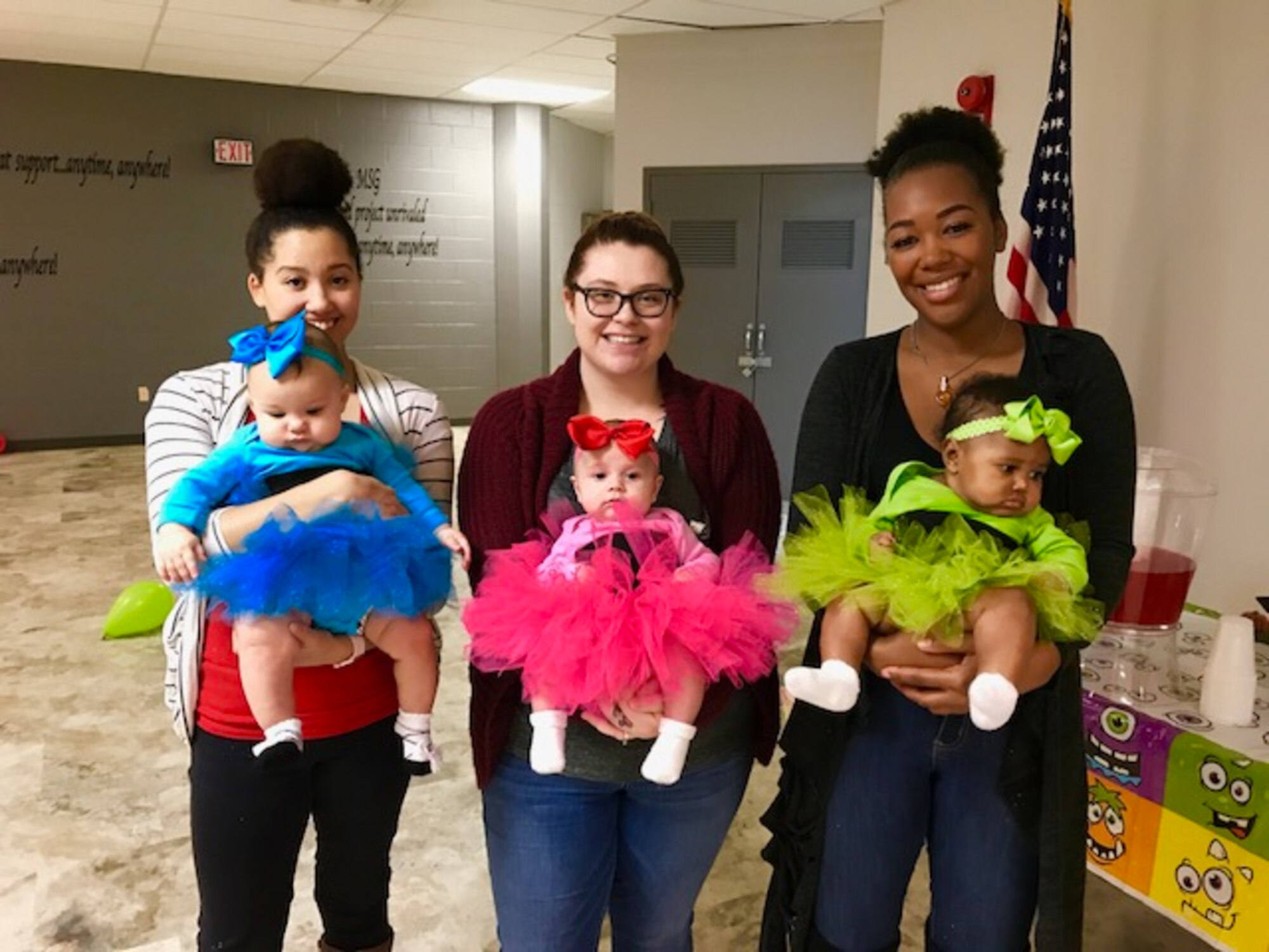 Mothers assigned to the 28th Security Forces Squadron, hold their children for a photo during a squadron event in the Base Defense Operations Center on Ellsworth Air Force Base, S.D., Oct. 27, 2017. Families of SFS personnel will soon be able to have access to the Little Defender’s Den, a family room that gives them the option of bringing their children with them during a recall or squadron events, as well as have a safe and comfortable place for mother’s to pump or breastfeed. (Courtesy photo)