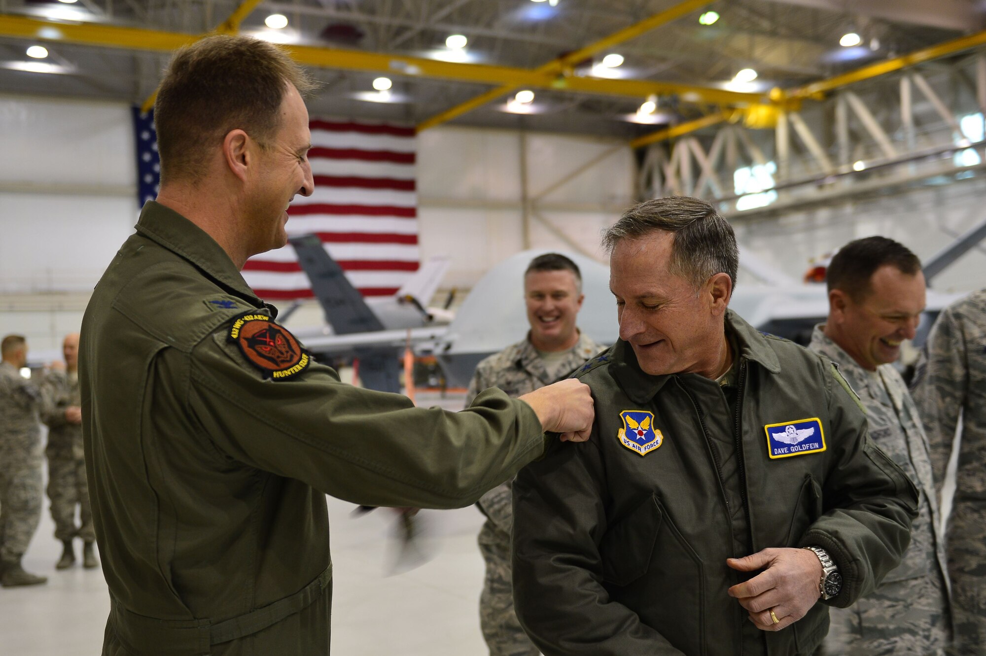 Col. Cheater, 432nd Wing/432nd Air Expeditionary Wing commander, puts the 432nd WG patch on Air Force Chief of Staff Gen. David L. Goldfein Jan. 9, 2017, at Creech Air Force Base, Nev. Goldfein toured operational squadrons around the base to meet with 432nd Wing/432nd Air Expeditionary Wing and 799th Air Base Group Airmen. (U.S. Air Force photo/Airman 1st Class Haley Stevens)