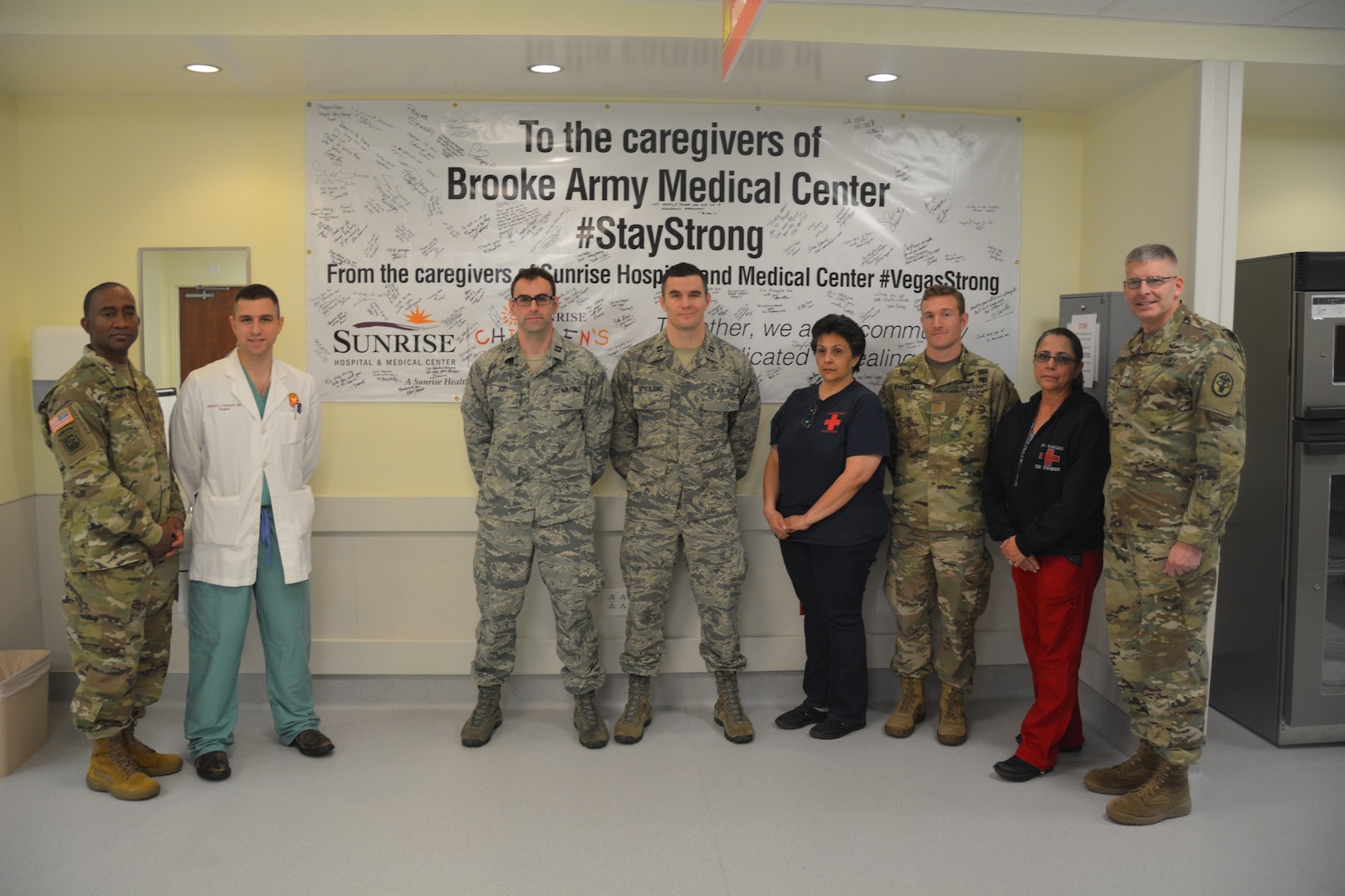 Brooke Army Medical Center Commanding General Brig. Gen. Jeffrey Johnson (far right), Command Sgt. Maj. Diamond Hough (far left) and Emergency Department personnel pose in front of a #StayStrong banner in the ED.
Sunrise Hospital and Medical Center sent the banner as a show of support to BAMC after the Sutherland Springs shooting Nov. 5, 2017. Sunrise Hospital treated more than 200 injured in the Las Vegas shooting last October. BAMC, which treated eight victims from Sutherland Springs, plans to rotate the banner throughout the hospital in the coming months to share the banner, which is filled with well-wishes and messages of hope and support.