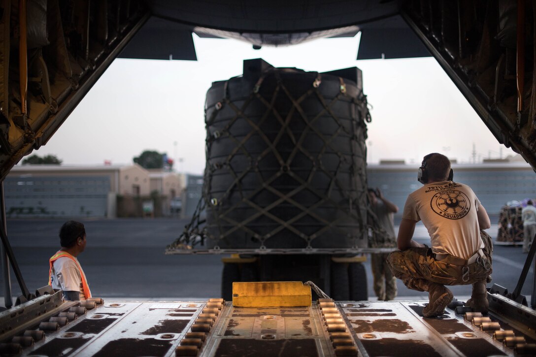 Airmen use a forklift to load cargo onto a C-130J Super Hercules.