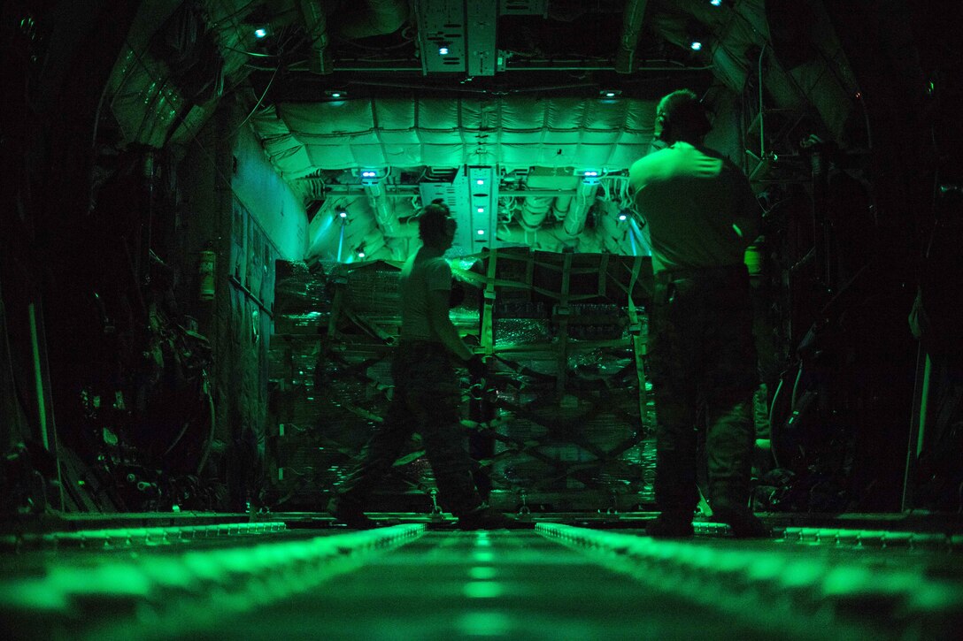 Airmen load pallets of cargo onto a C-130J Super Hercules.
