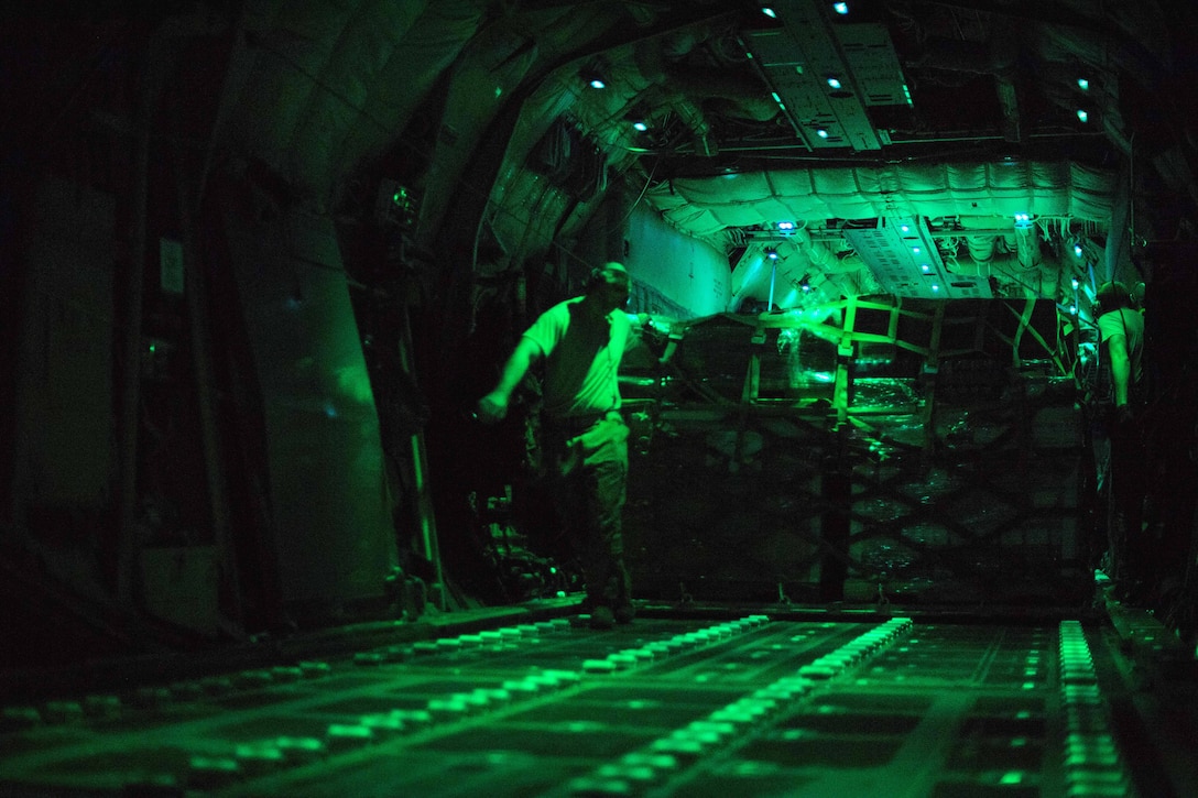 Airmen off load pallets of cargo from a C-130J Super Hercules.